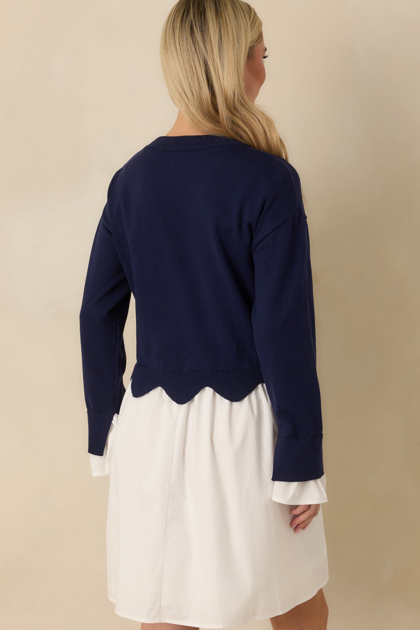 Navy and white mini dress displaying the relaxed silhouette from the rear with a smooth knit bodice and flowing woven skirt.
