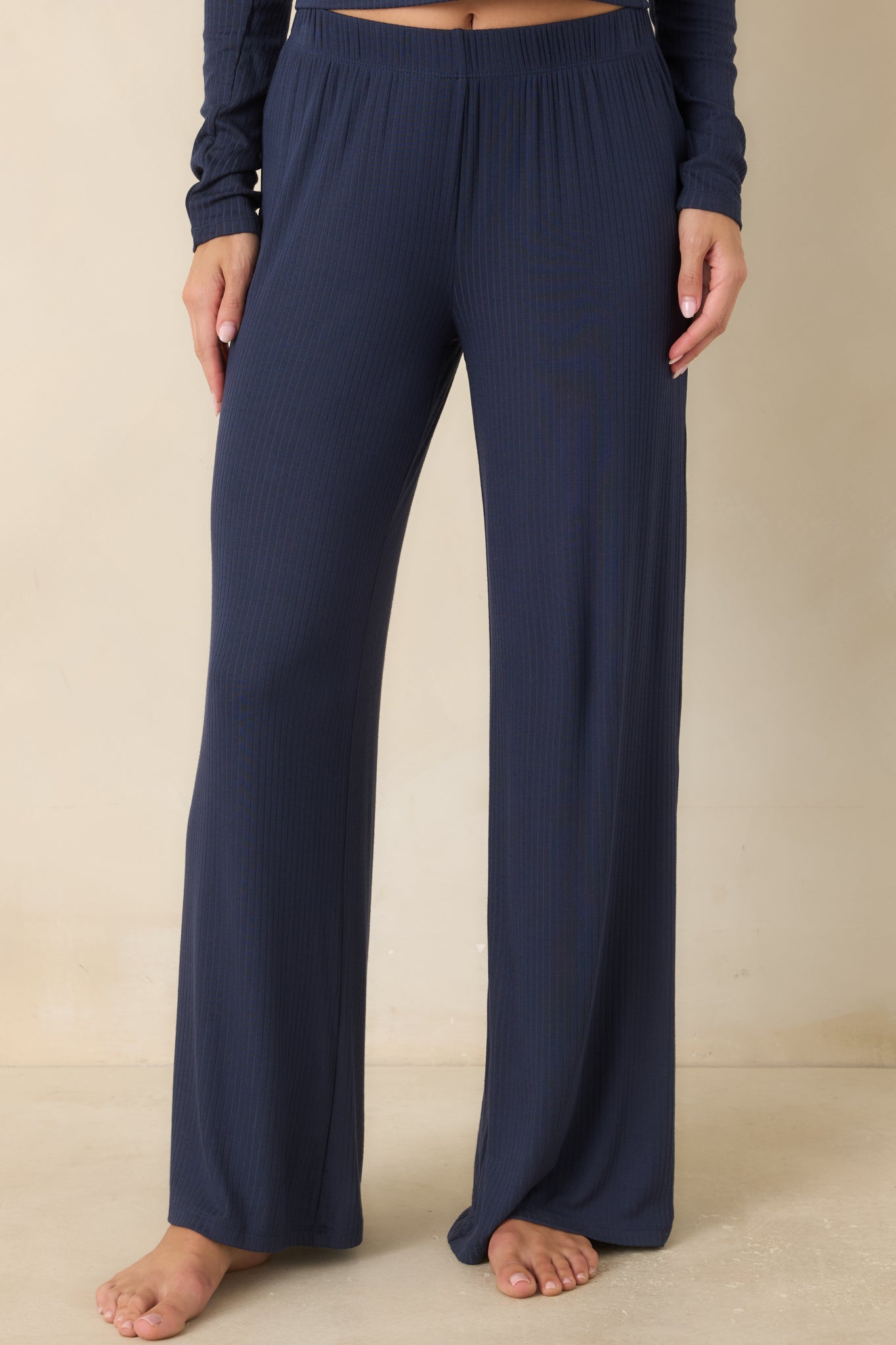 Navy ribbed pants featuring a relaxed wide leg silhouette and soft rib knit.