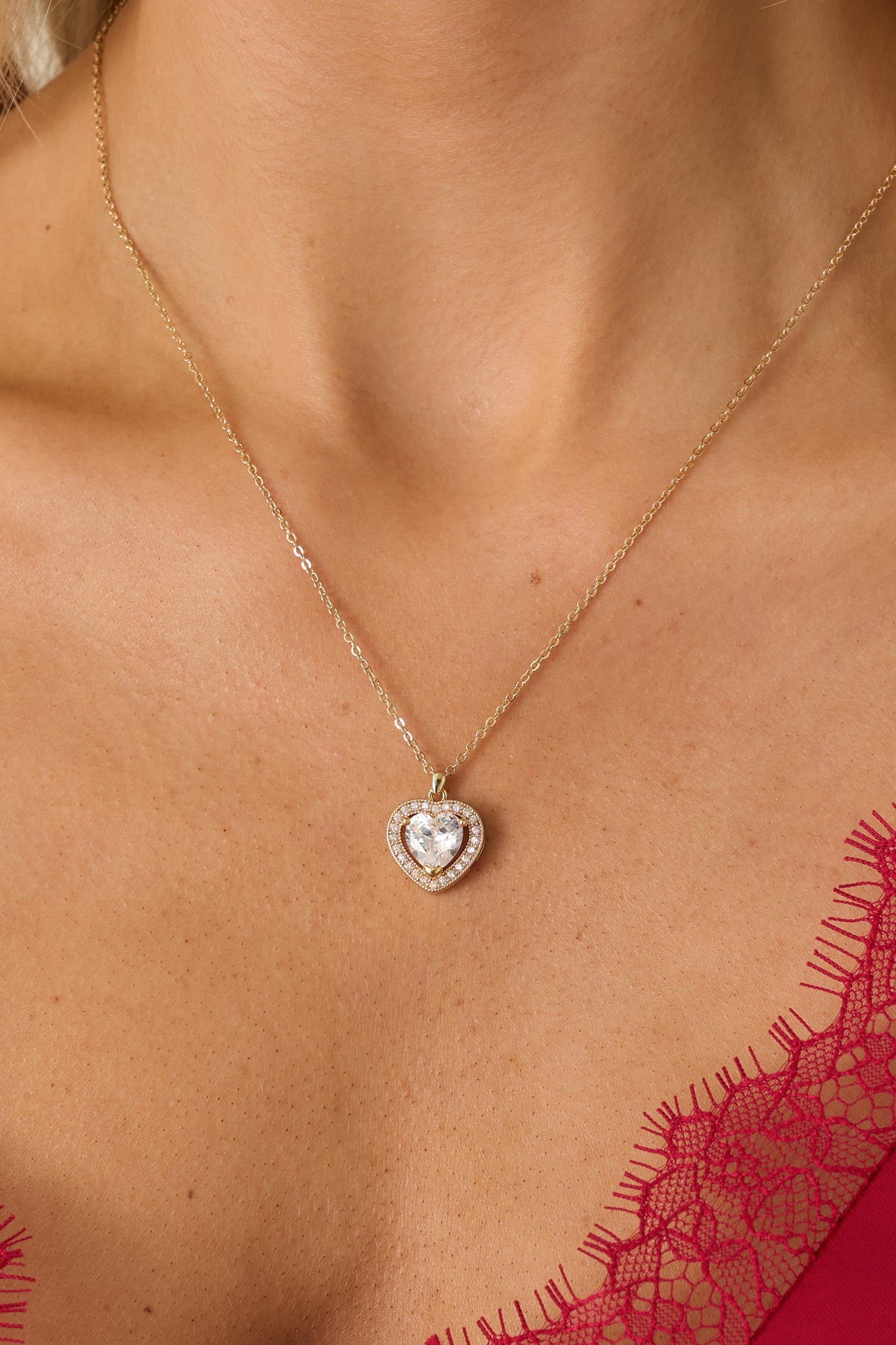 Necklace featuring a large rhinestone heart center, surrounded by encrusted smaller rhinestones, and secured with a lobster claw clasp.