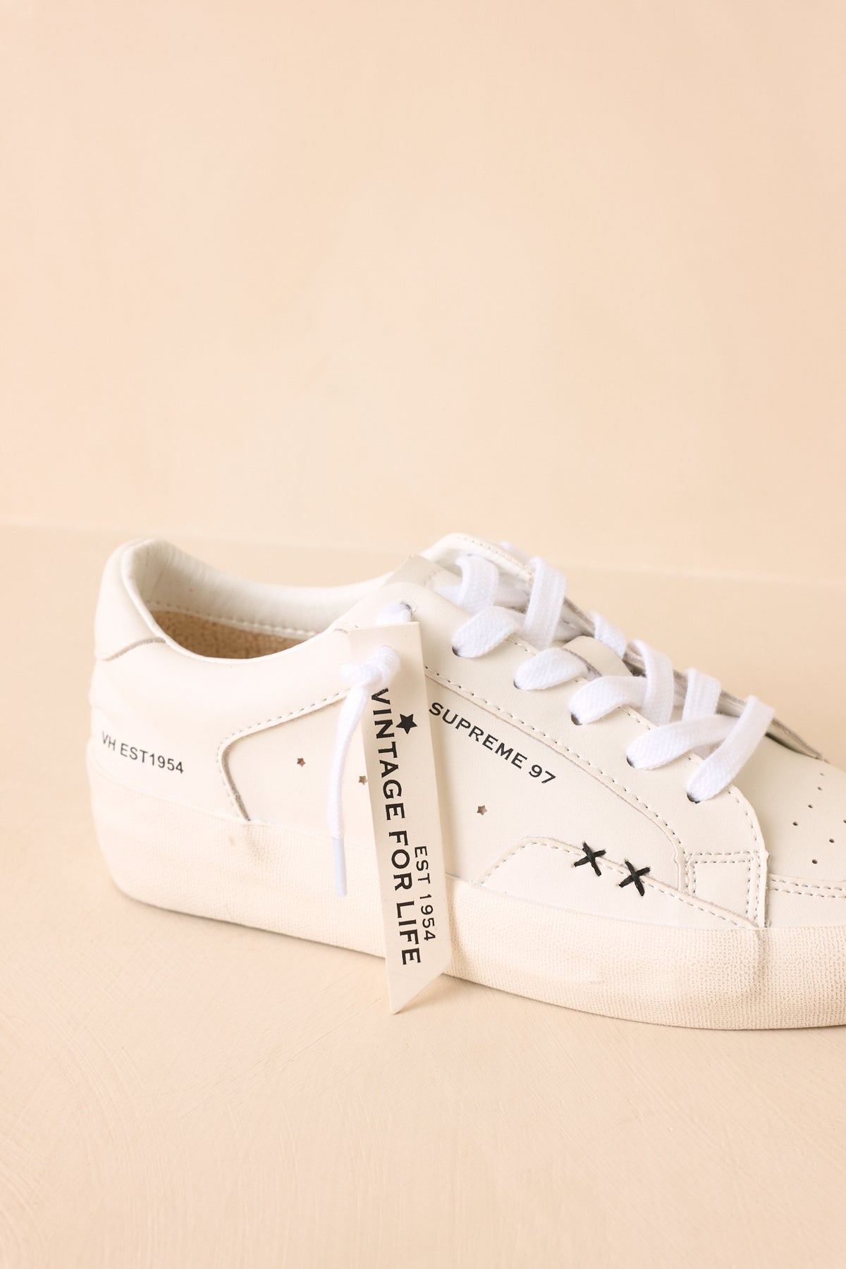 Close-up of neutral sneakers highlighting the refined texture, streamlined construction, and comfortable cushioned sole design.