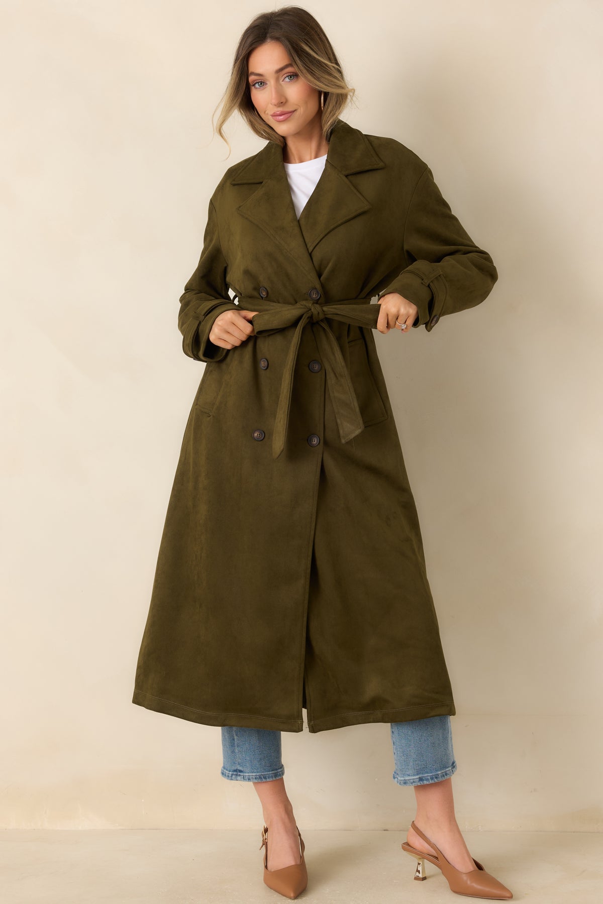 Longline coat with a classic notched collar, symmetrical buttons, and a belted waist.