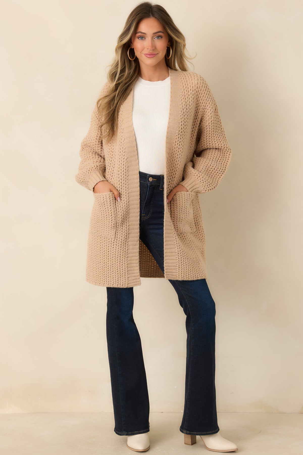 Oatmeal open-knit cardigan with a relaxed longline silhouette, roomy sleeves, and patch pockets.
