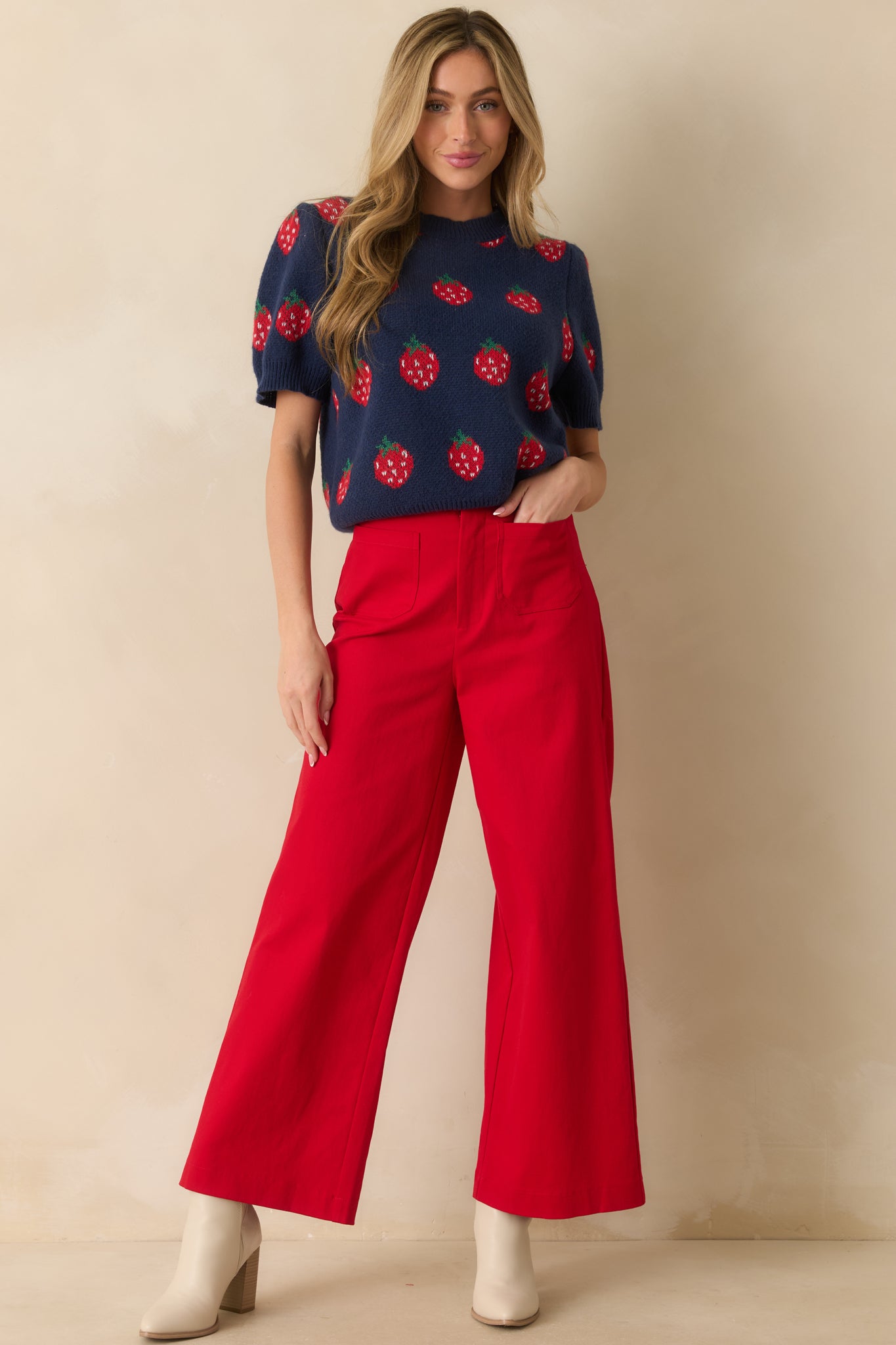 Cozy knit sweater in navy with ribbed edges and playful allover red strawberries.