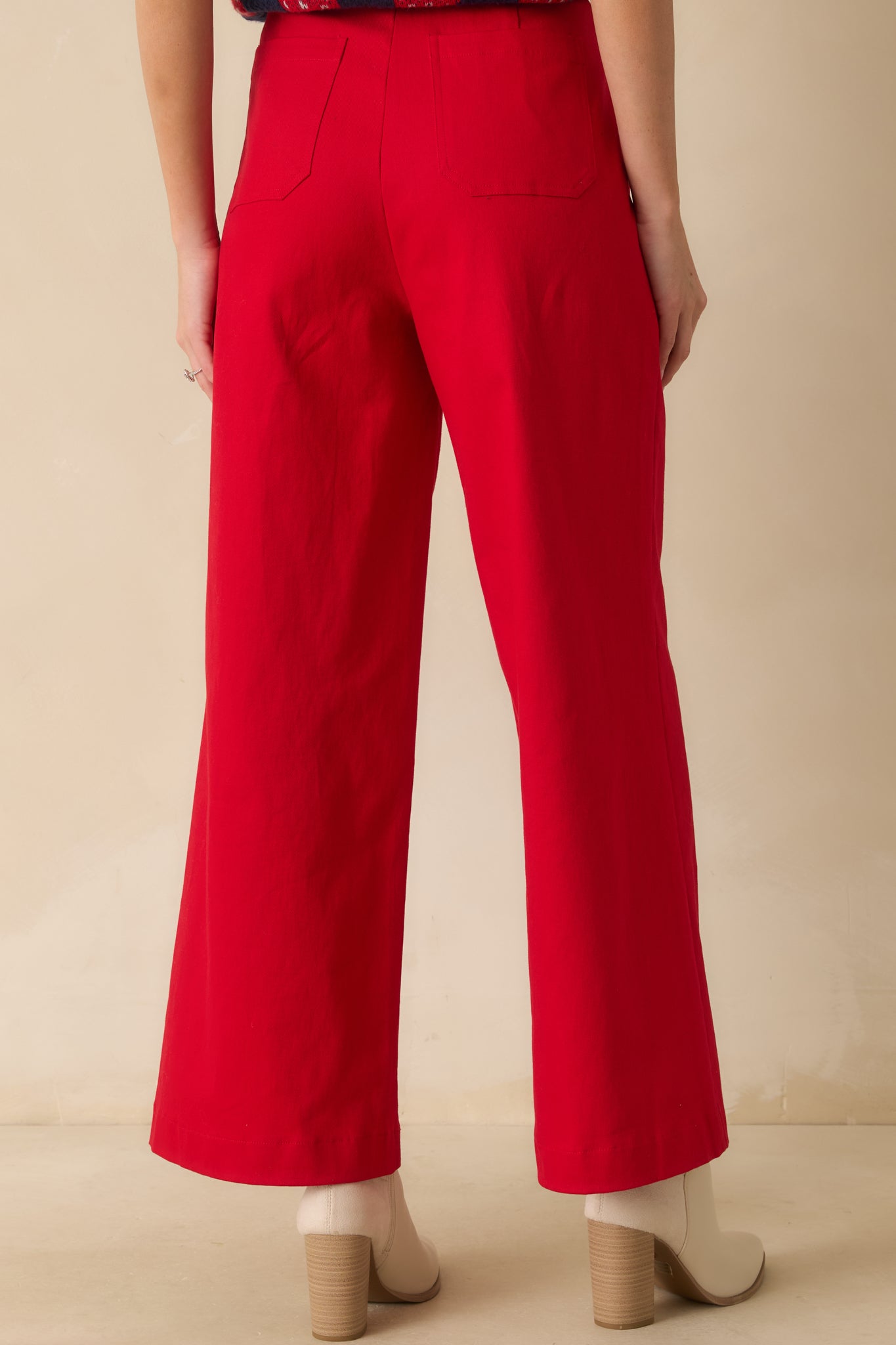 Rear view of red jeans showing back pockets, belt loops, and wide-leg fit in structured denim.