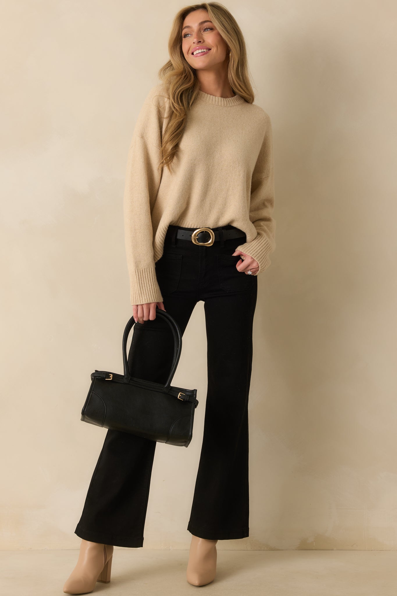 Full body front angle capturing the drape of the sleeves and cozy silhouette of the sweater.