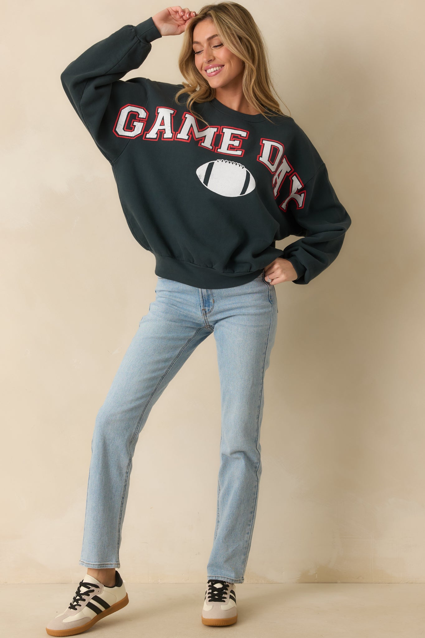 Vintage black crewneck sweatshirt featuring a bold white and red “GAME DAY” graphic with a football motif across the chest.