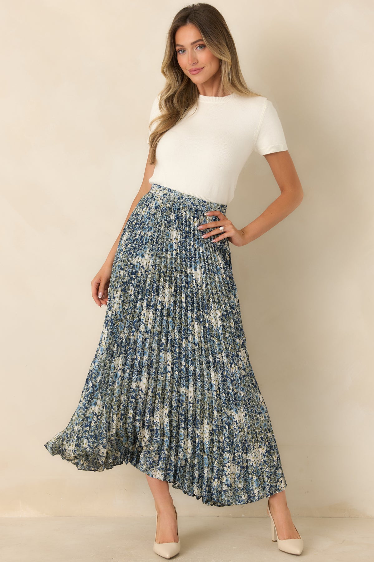 Pleated maxi skirt with muted olive foliage, soft blue flowers, and a flowing full-length silhouette.