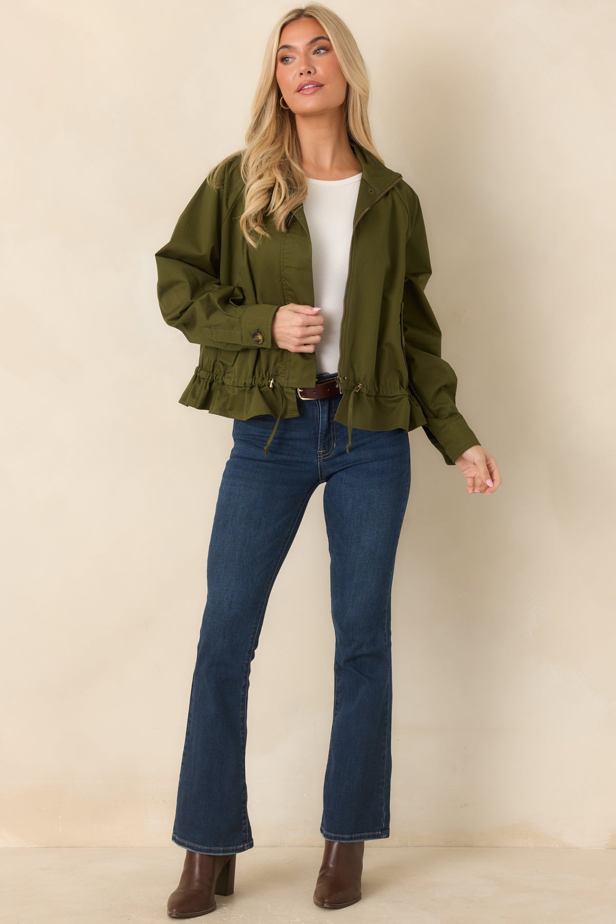 Olive jacket combines a lined cotton construction with snap details, practical front pockets, and an adjustable drawstring waist.