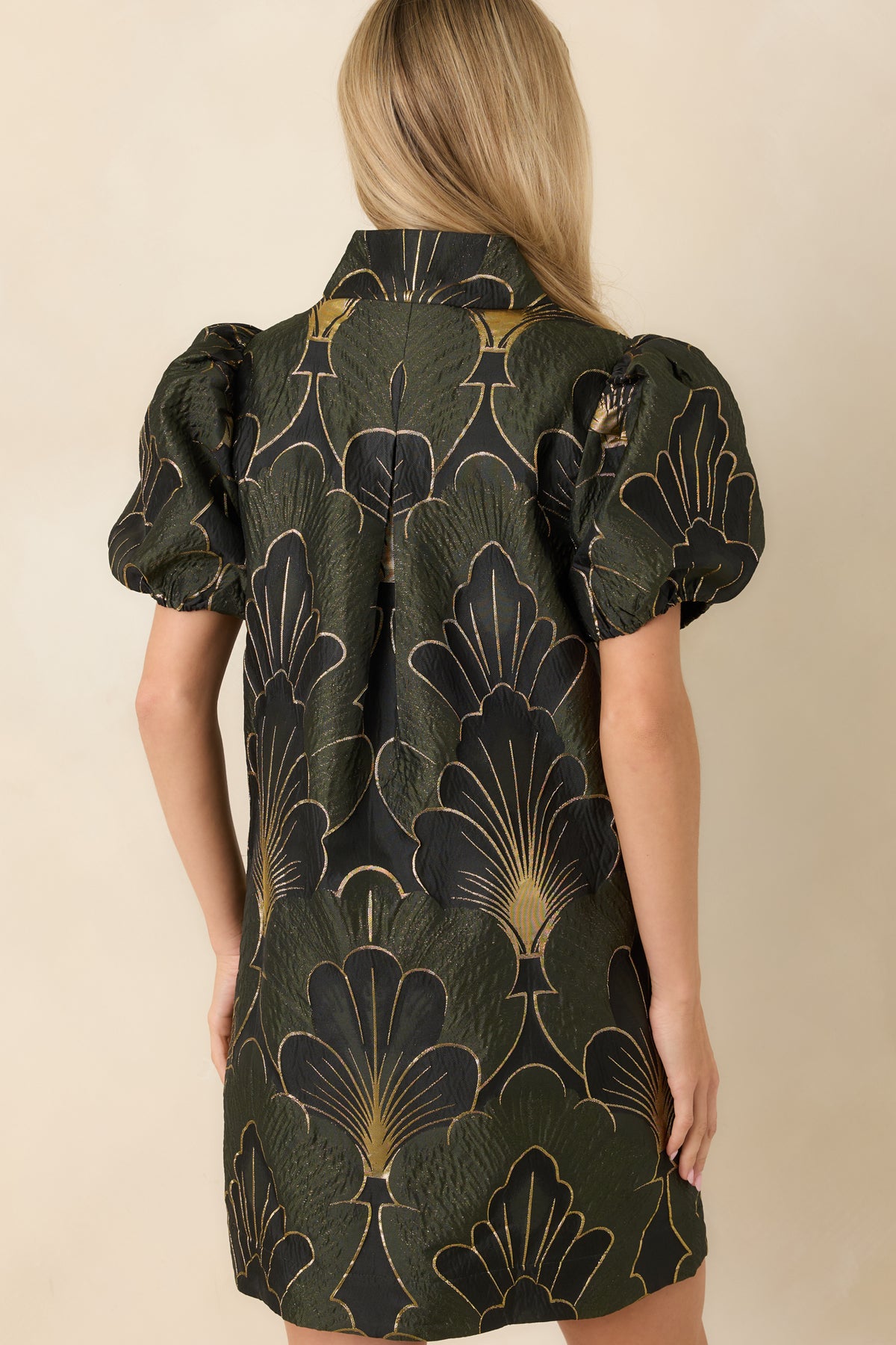 Back of the olive floral mini dress featuring a relaxed shift shape and a center back pleat.