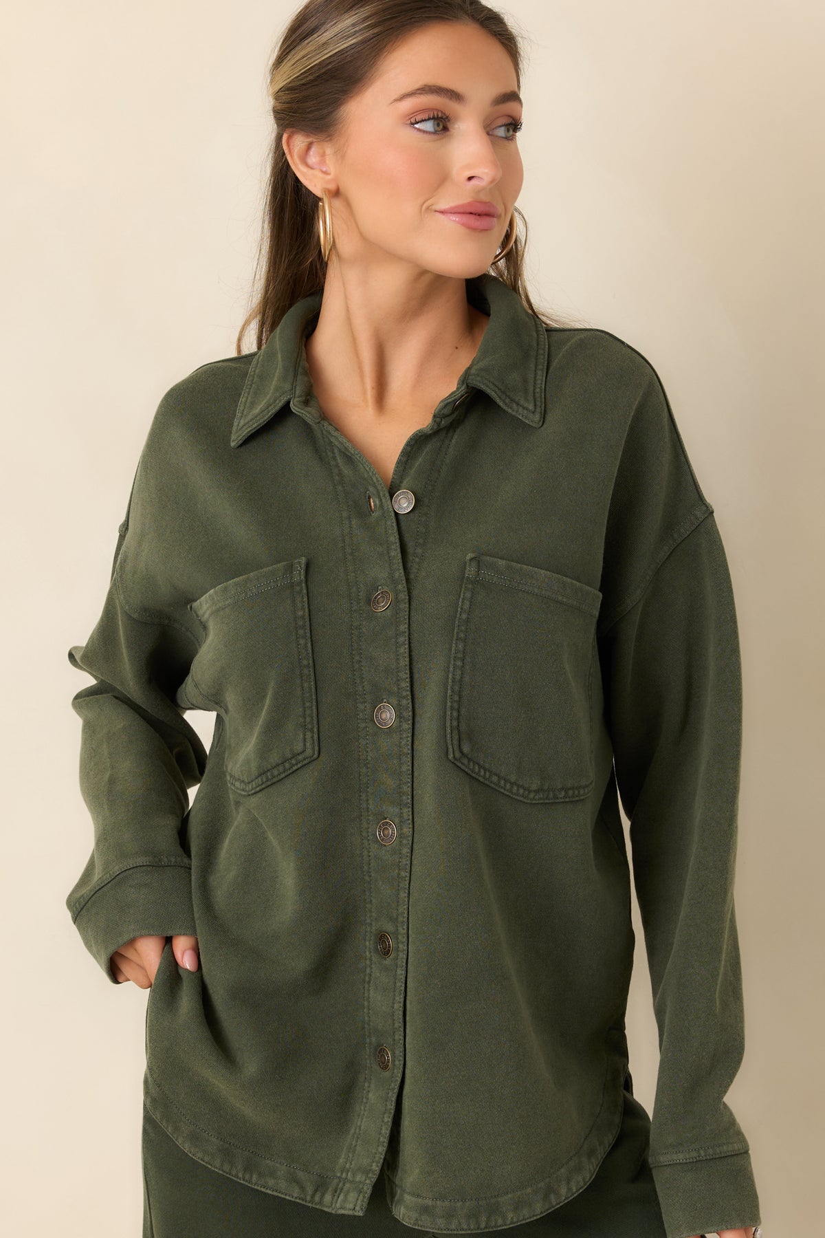 Pointed collar and full button-front closure on the washed olive cotton jacket.