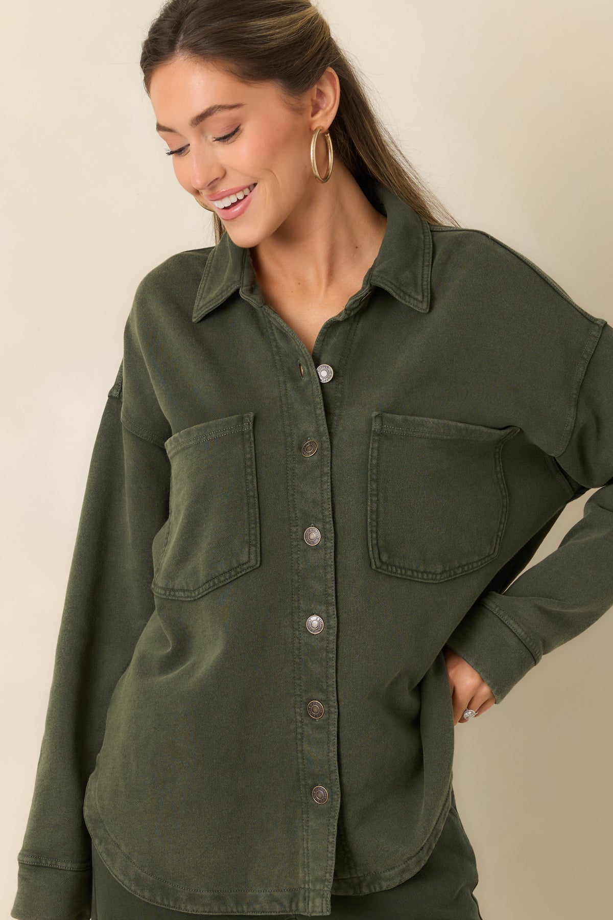 Close-up of the olive jacket’s washed French terry texture and button-front detailing.