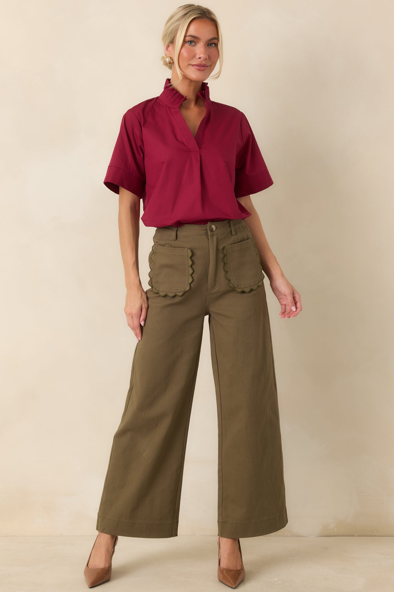 Olive green cotton pants featuring a high-rise waist, wide leg silhouette, and scalloped front patch pockets for a feminine finish.