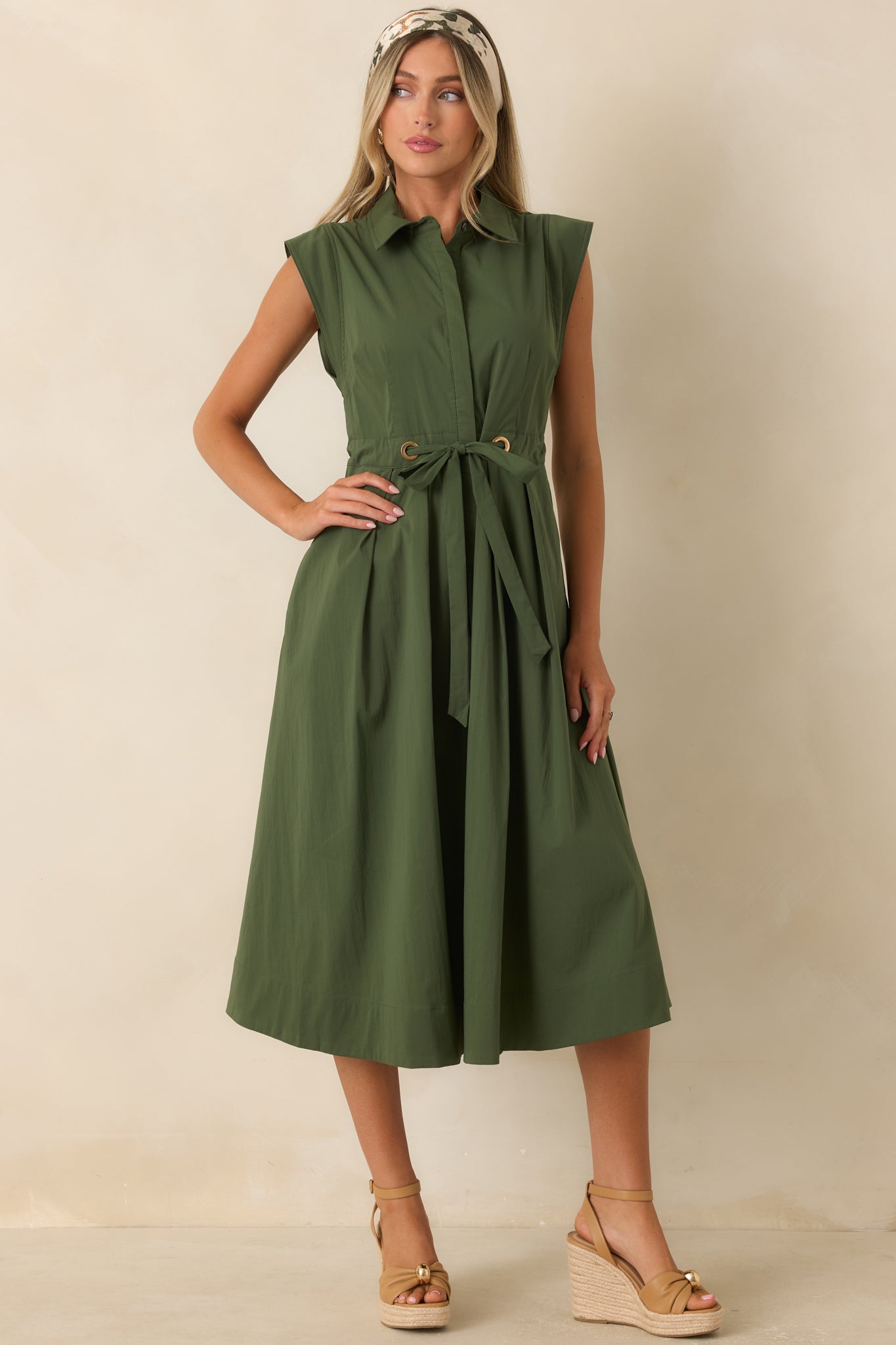 Olive green cotton poplin dress featuring a classic collar, cap sleeves, adjustable belt, and graceful full skirt silhouette.