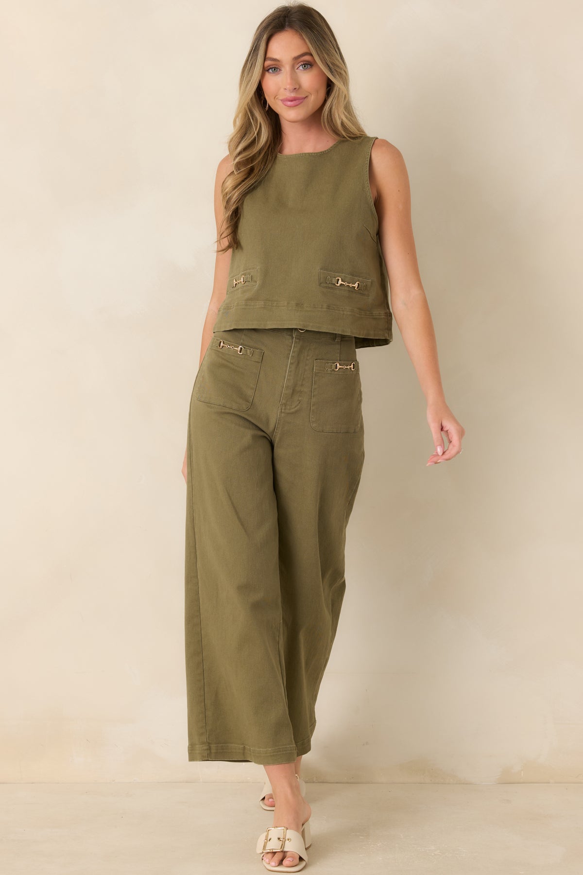 Olive green denim top featuring a sleeveless A-line silhouette, round neckline, and gold-tone horsebit accents.