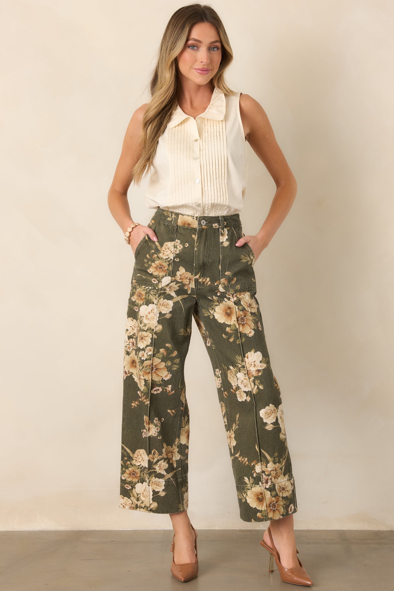 Olive green 100% cotton pants featuring an ivory floral print, high-rise waist, patch pockets, and a relaxed wide-leg silhouette.