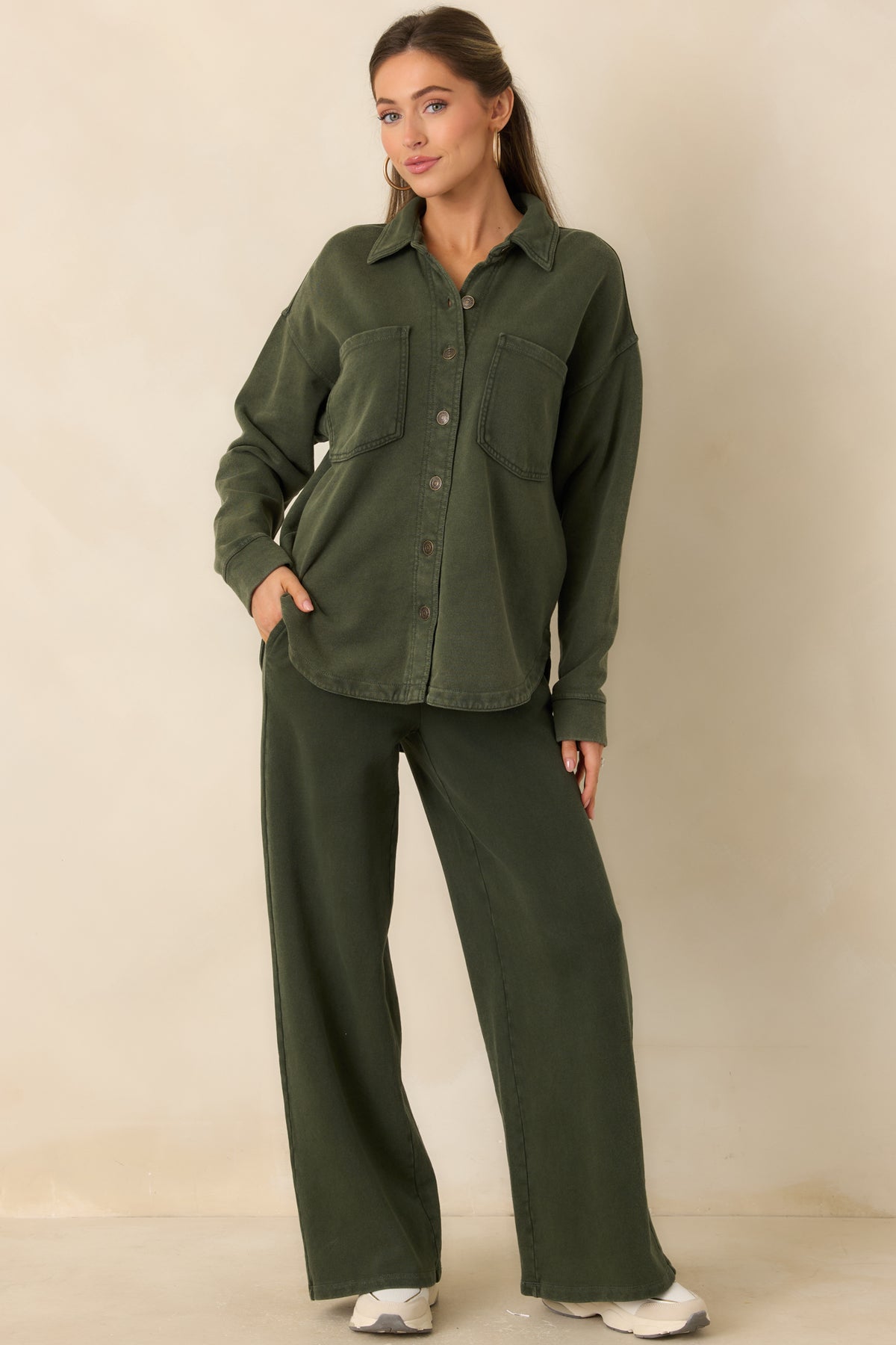 Muted olive green French terry pants with an elastic waistband, cream drawstring, and functional side pockets.