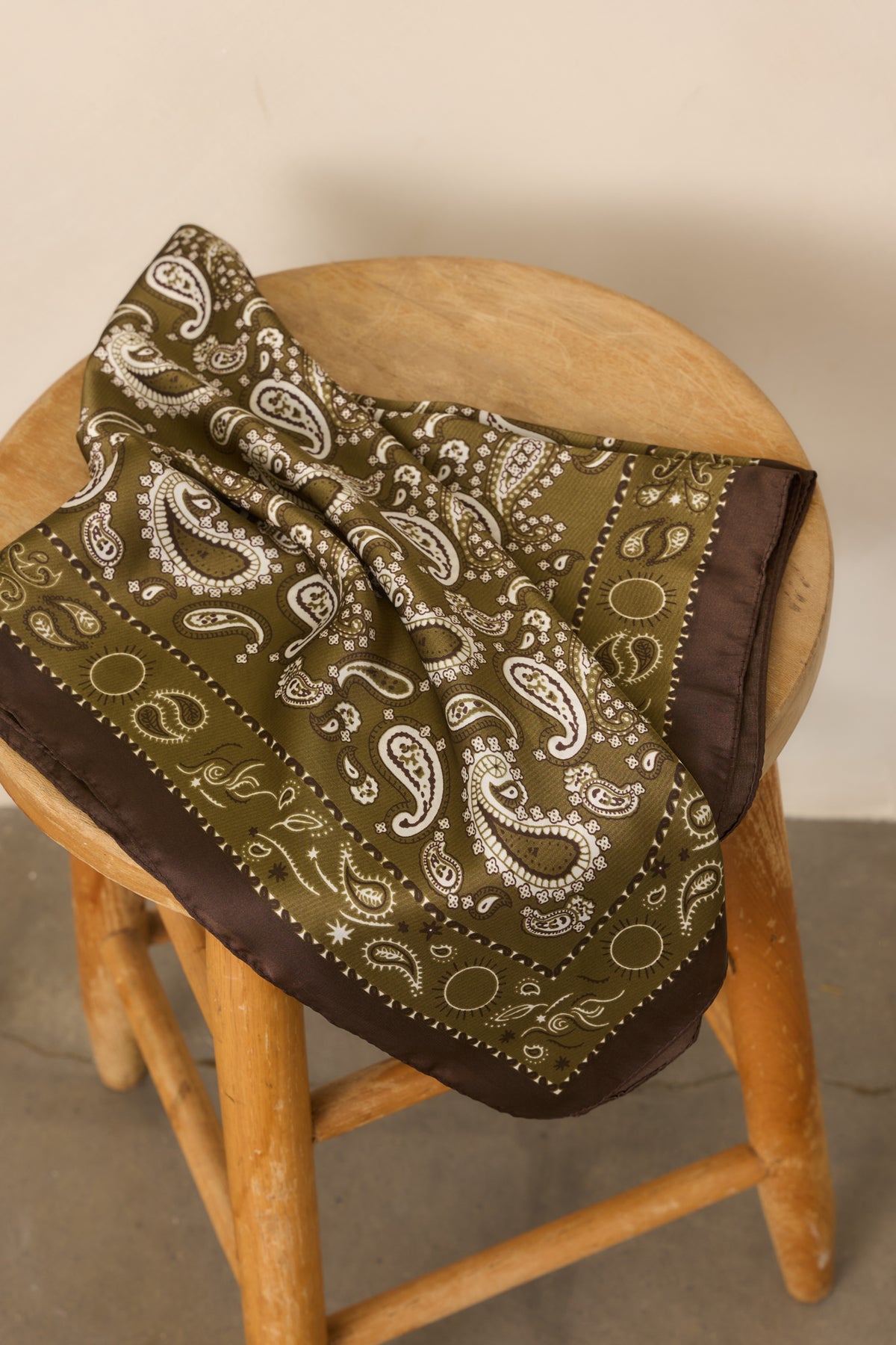 Olive green, ivory, and brown paisley hair scarf with a smooth satin finish and contrasting border.