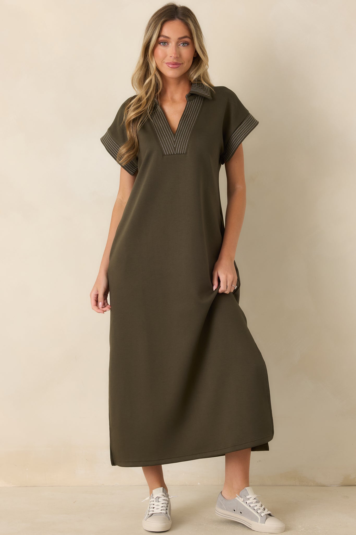 Olive green maxi dress with a soft knit texture, striped accents, side slits, and an effortless relaxed silhouette.