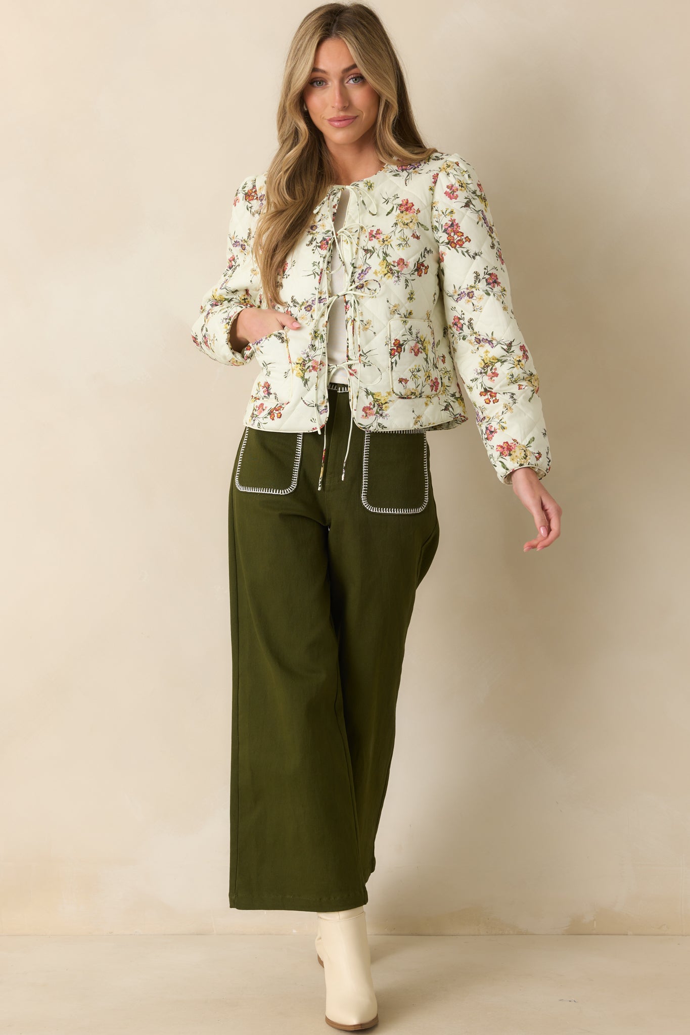 Olive green pants highlighting white whipstitch trim detailing along seams.