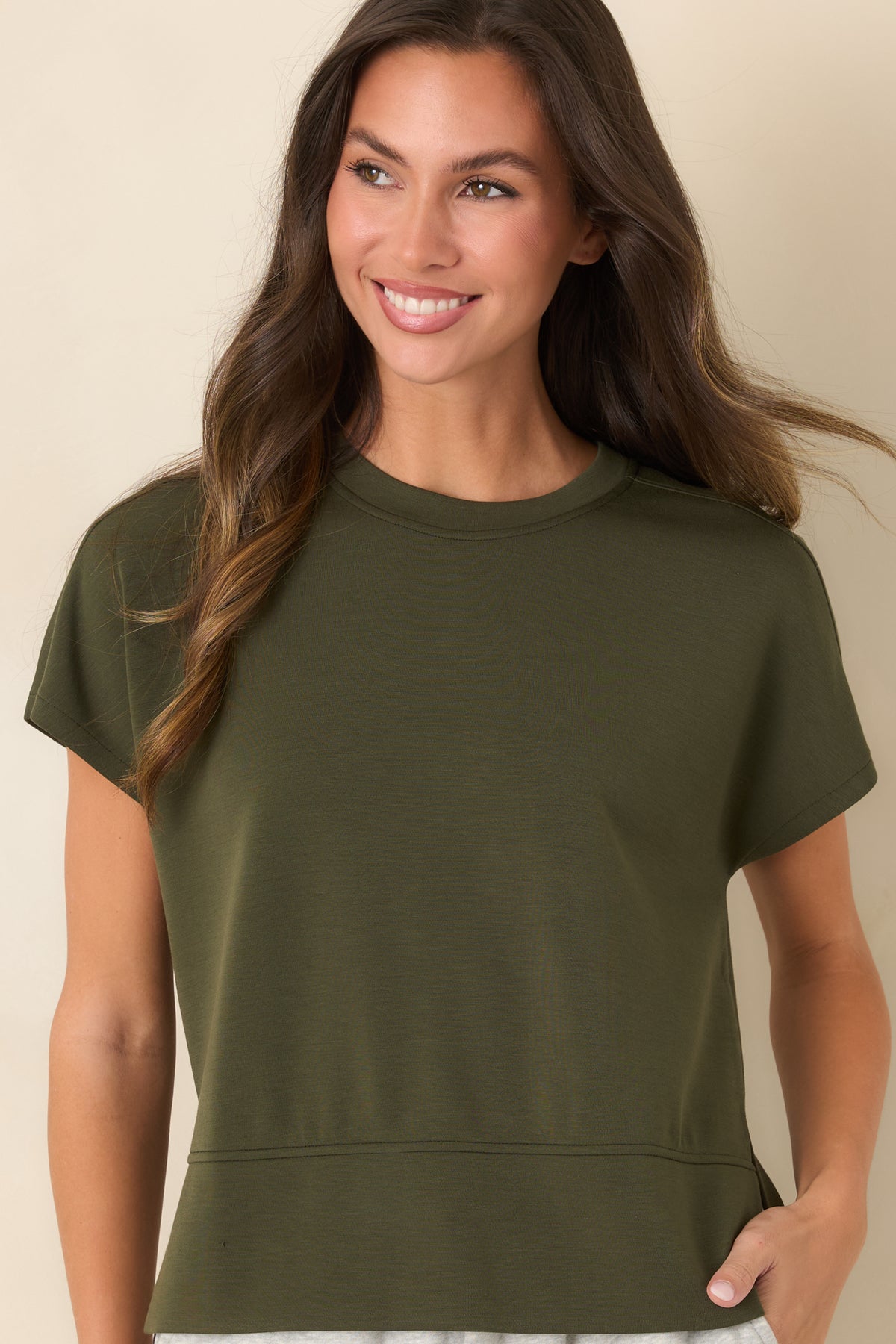 Olive-green spacer fabric top with smooth construction, short sleeves, and relaxed side openings.
