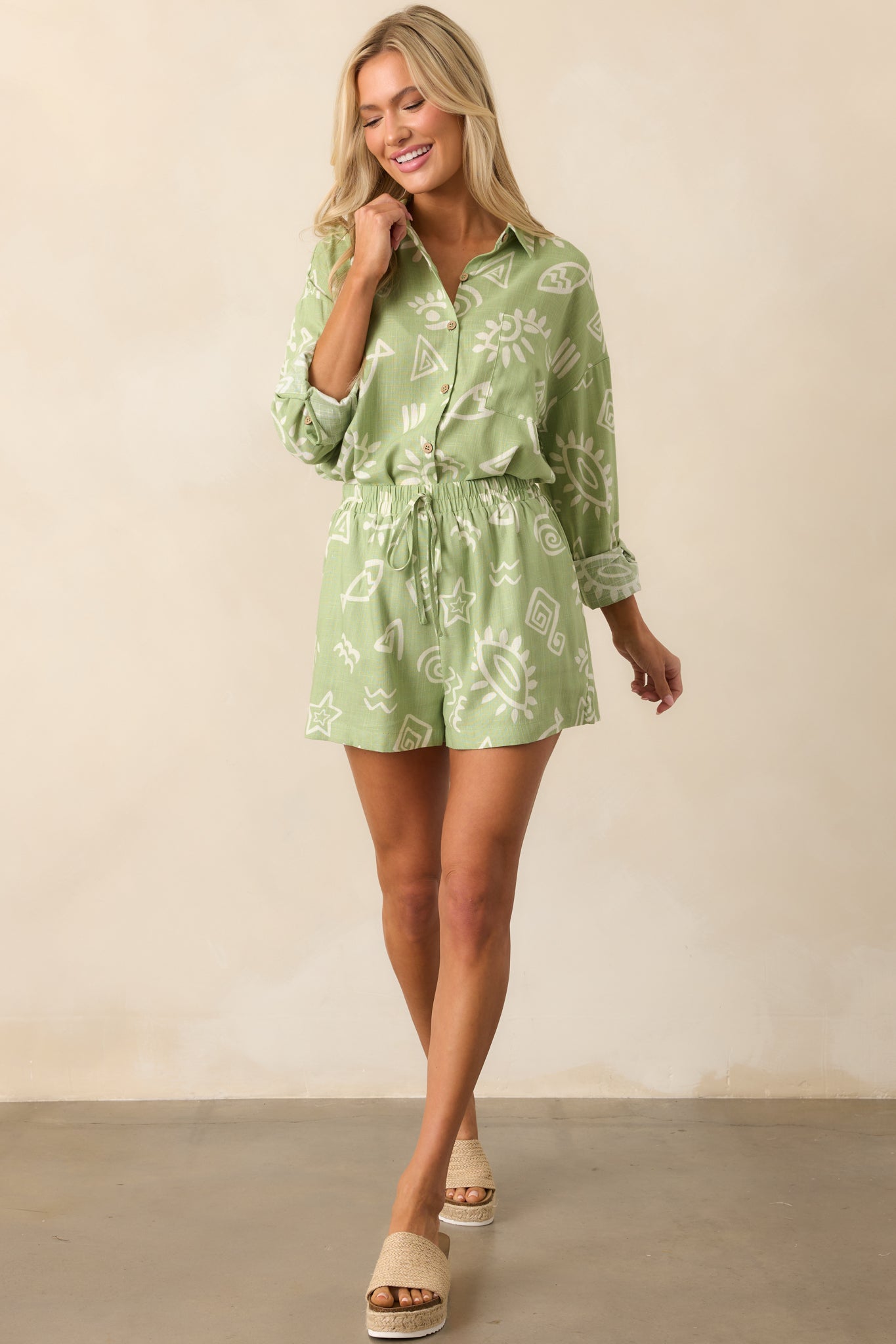 Front view of the olive green top featuring an ivory tropical print, collared neckline, and relaxed silhouette in a lightweight linen blend.