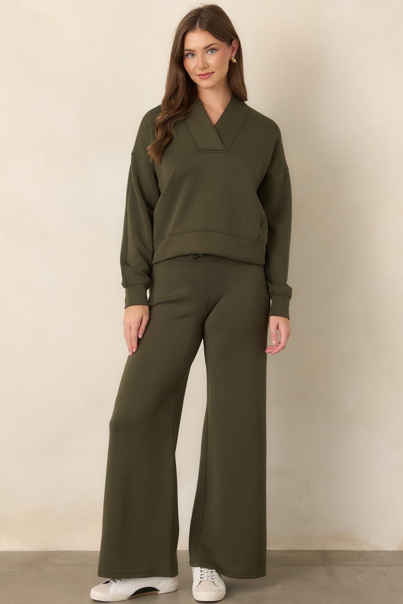 Olive-green long-sleeve top defined by a wide V-neck collar, dropped shoulders, and softly structured relaxed fit.