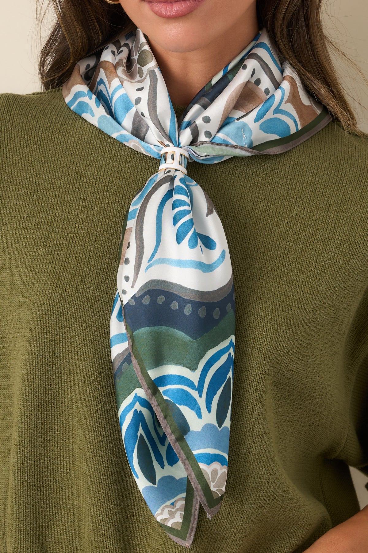 Silky polyester satin scarf featuring an enlarged multicolor medallion motif framed by a slim green and brown border.
