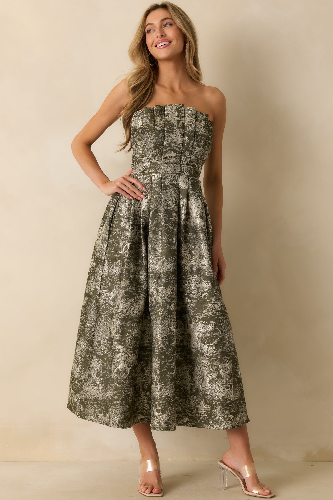 Elegant olive midi dress with ivory castle and unicorn jacquard, structured pleated top, and flowing A-line skirt.
