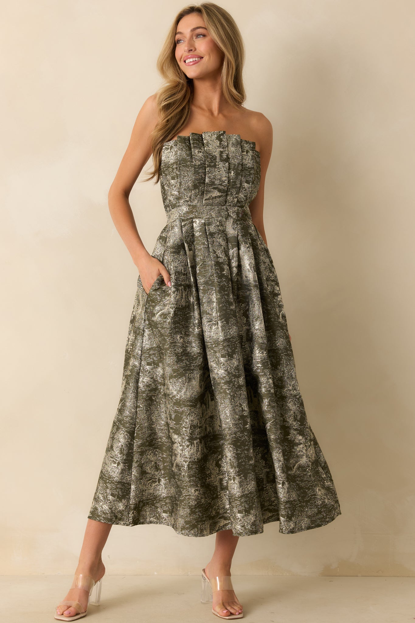 Olive strapless midi dress with a voluminous A-line skirt, pleated bodice, and whimsical jacquard motifs in ivory.