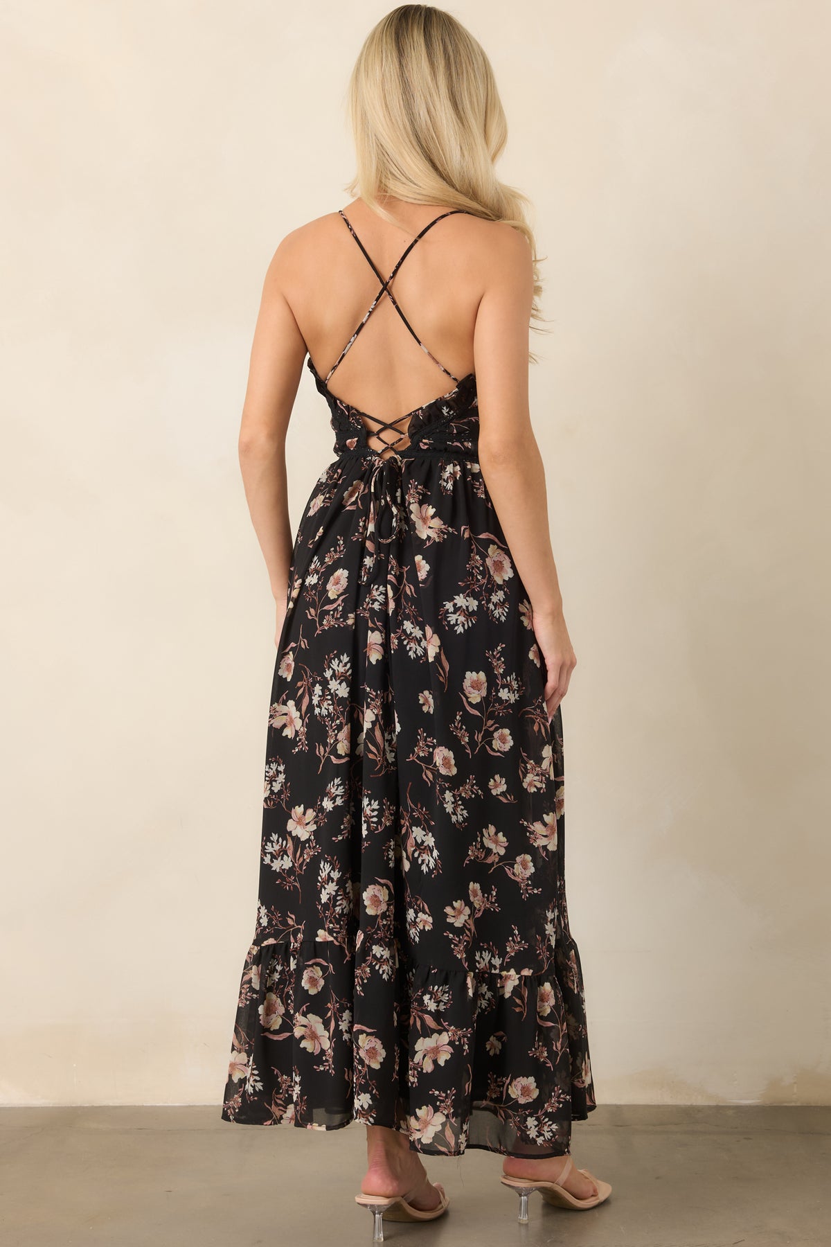 Open back of the sheer black floral dress with slender crossed straps leading into a lace-up tie.
