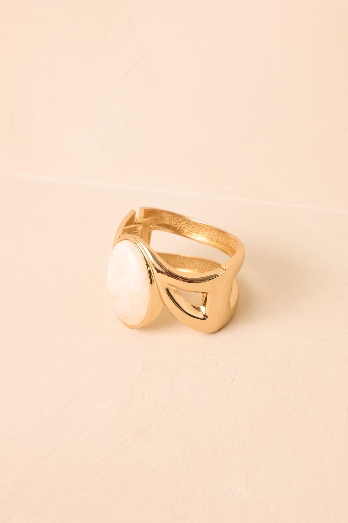 Close-up of the open cuff bracelet highlighting the oval ivory cabochon and sleek geometric framing around the centerpiece.