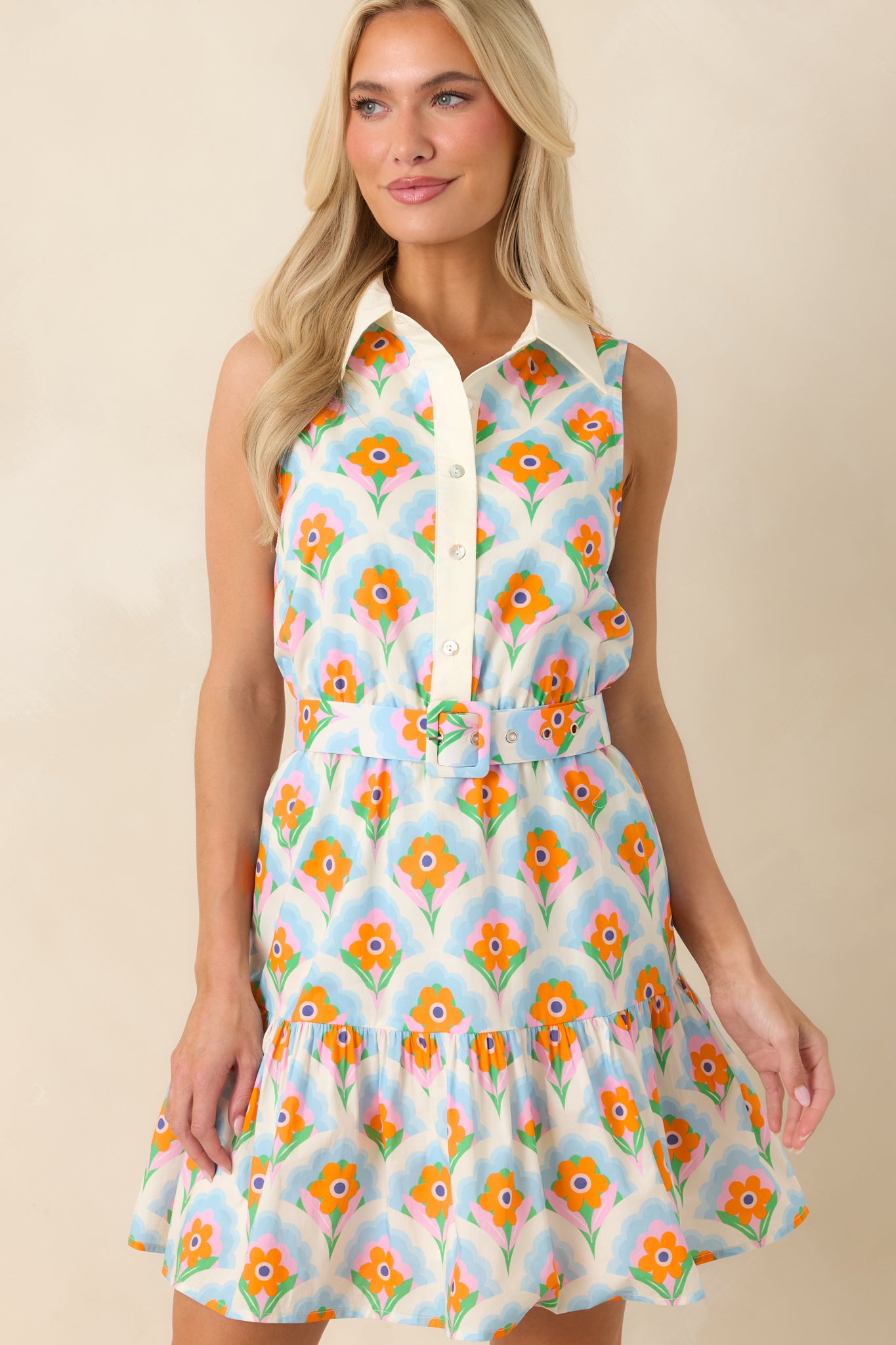 Orange and light blue floral pattern showcased with the sleeveless silhouette and tailored button-front design.