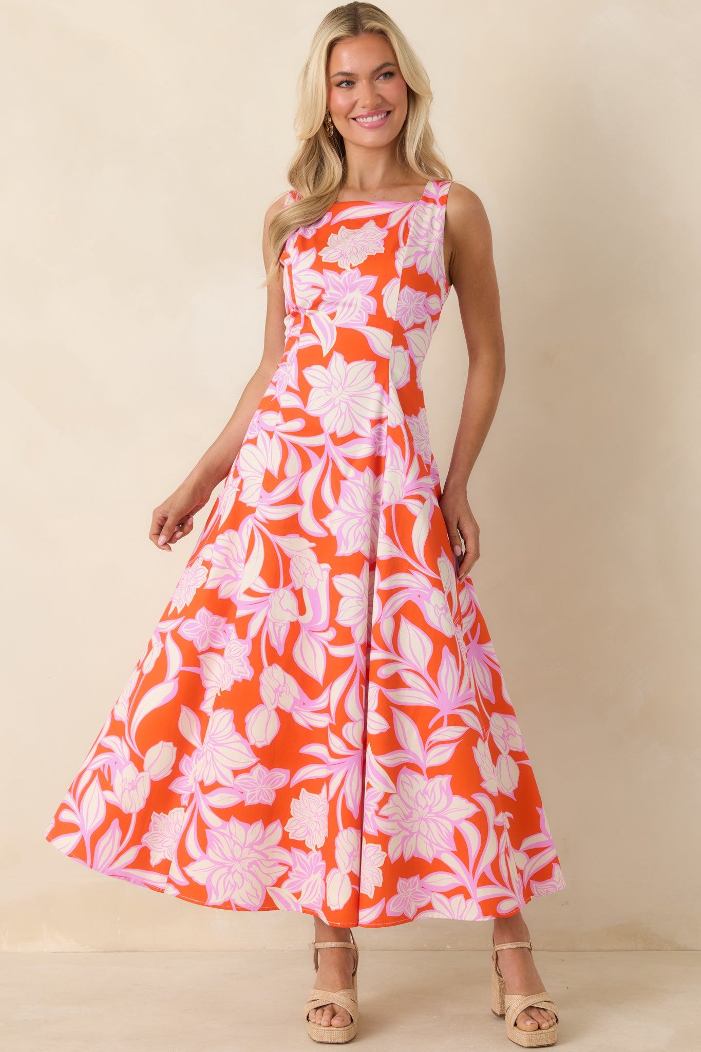 Orange maxi dress with orchid pink floral pattern and sweeping skirt.