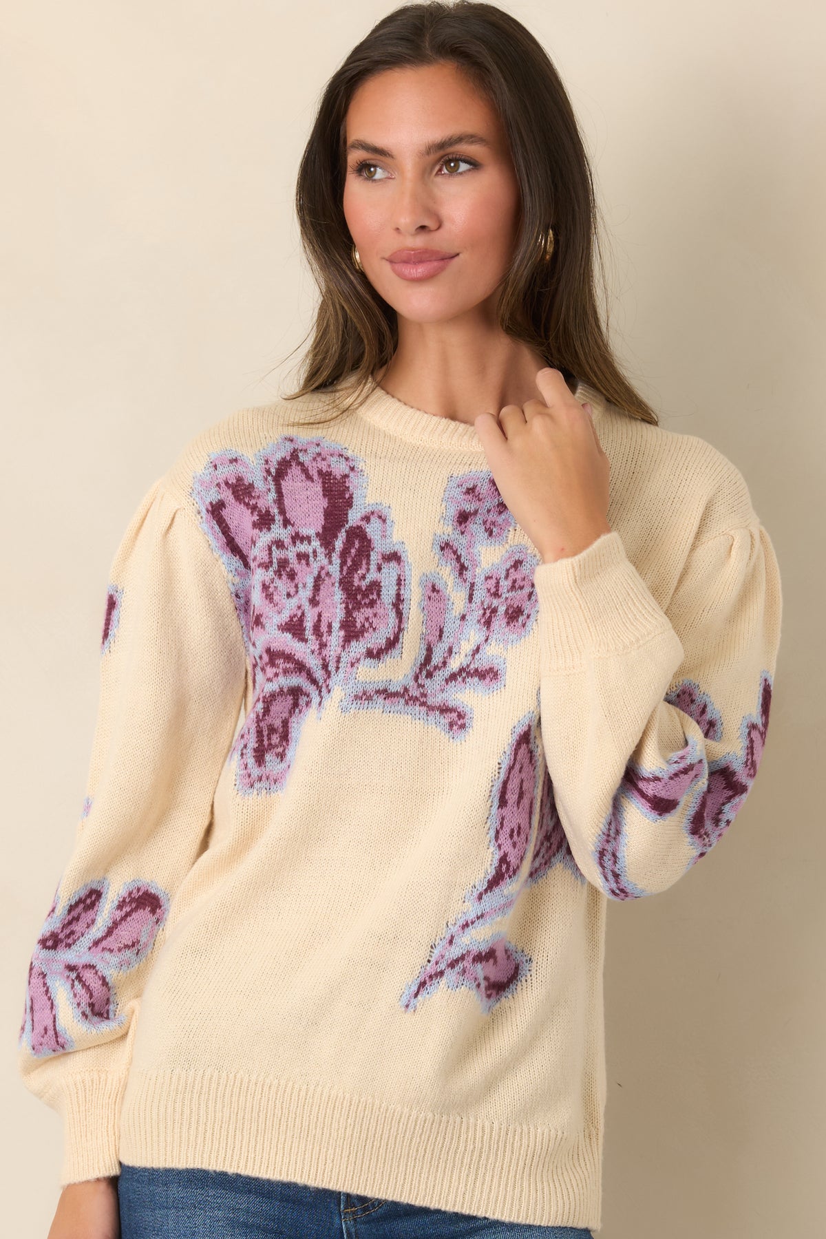 Oversized burgundy and pink blooms create a striking floral motif across the vanilla knit, accented with pale blue outlines.