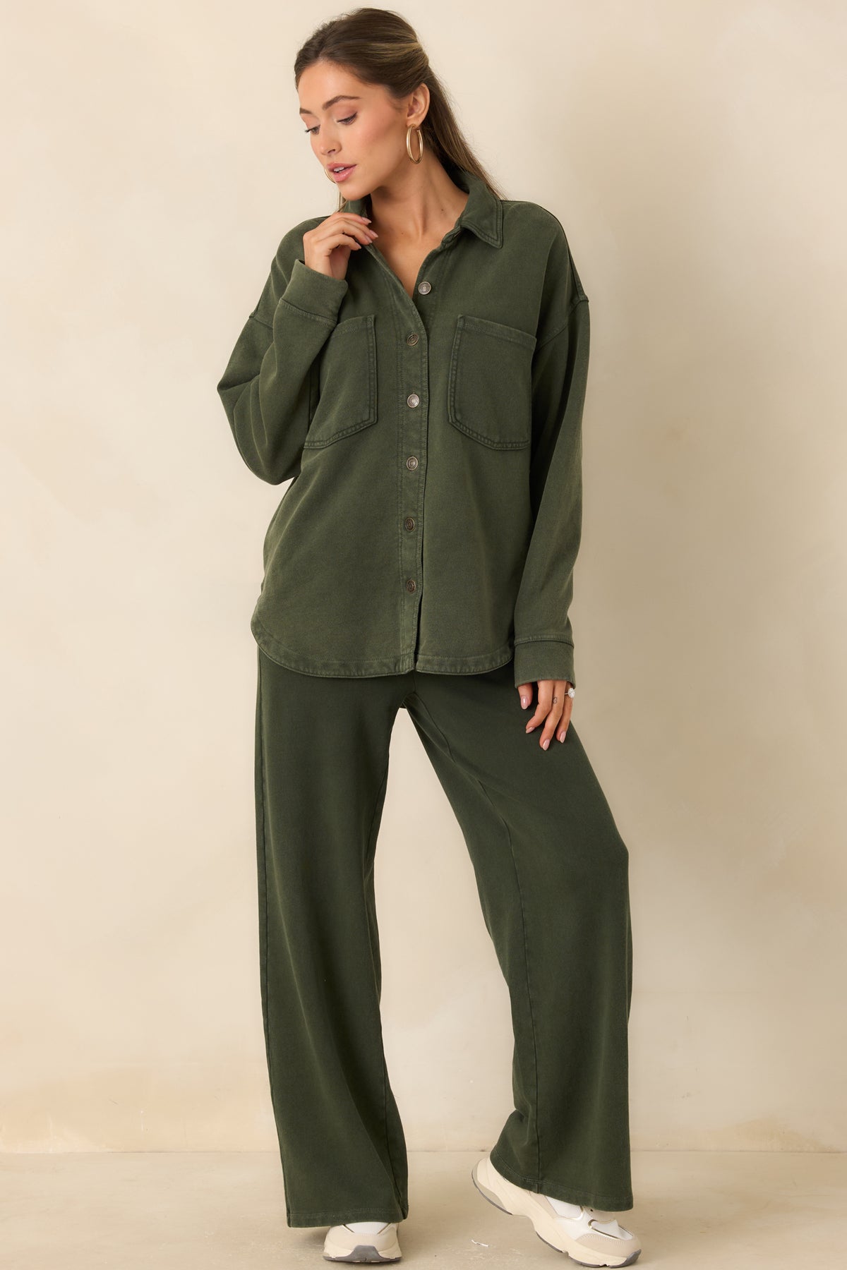 Oversized olive green jacket with buttoned cuffs, large chest patch pockets, and a lived-in finish.