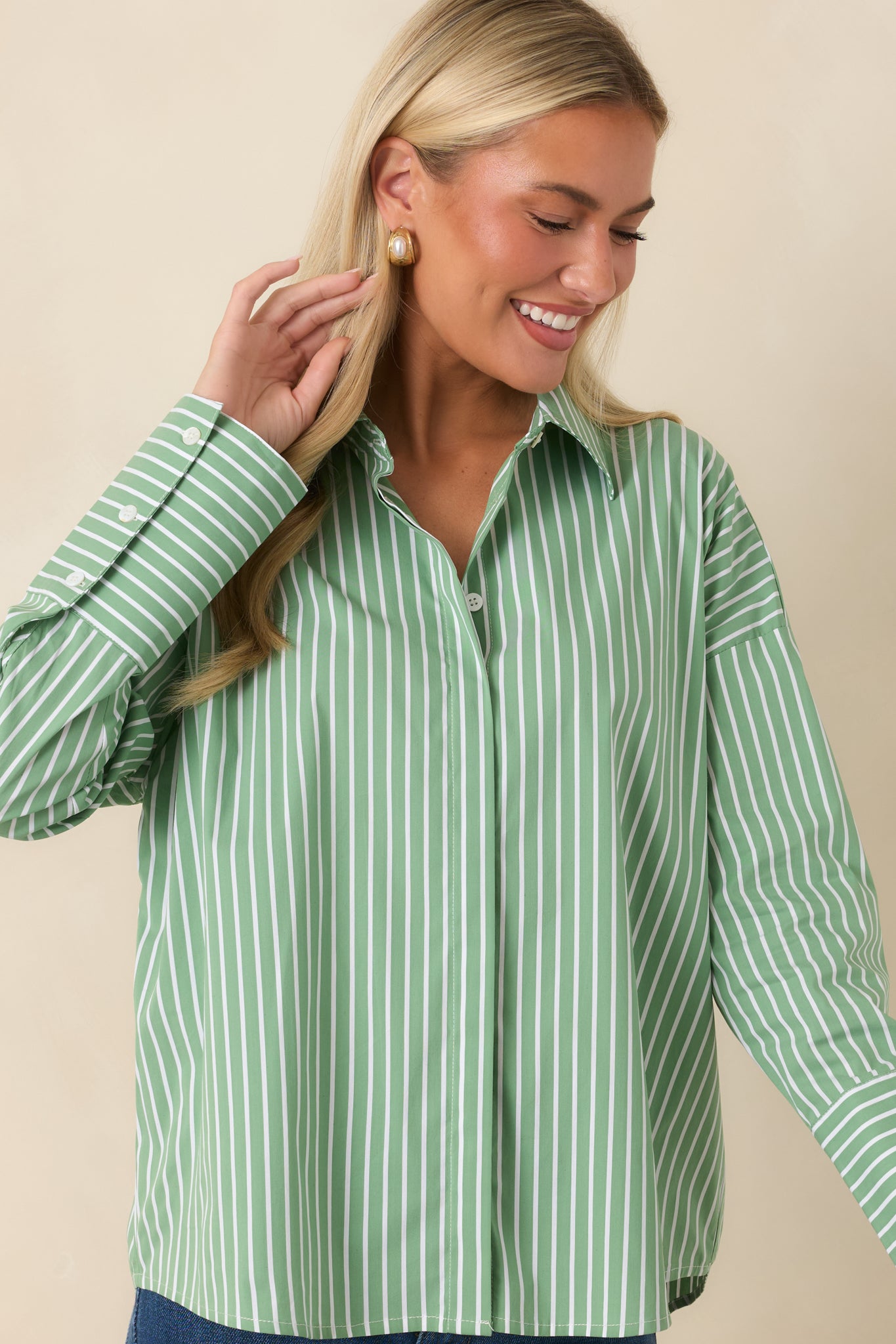 Front detail of the oversized shirt featuring the relaxed fit, button closure, and tailored design elements.