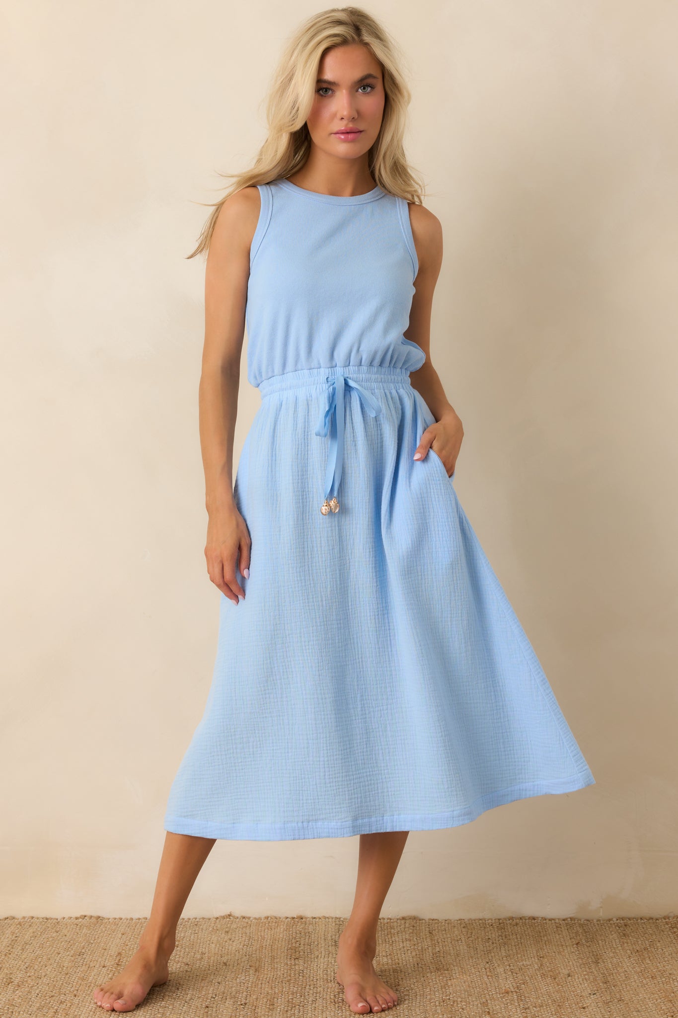 Relaxed fit midi dress featuring a sleeveless design, round neckline, and cinched drawstring waist detail.