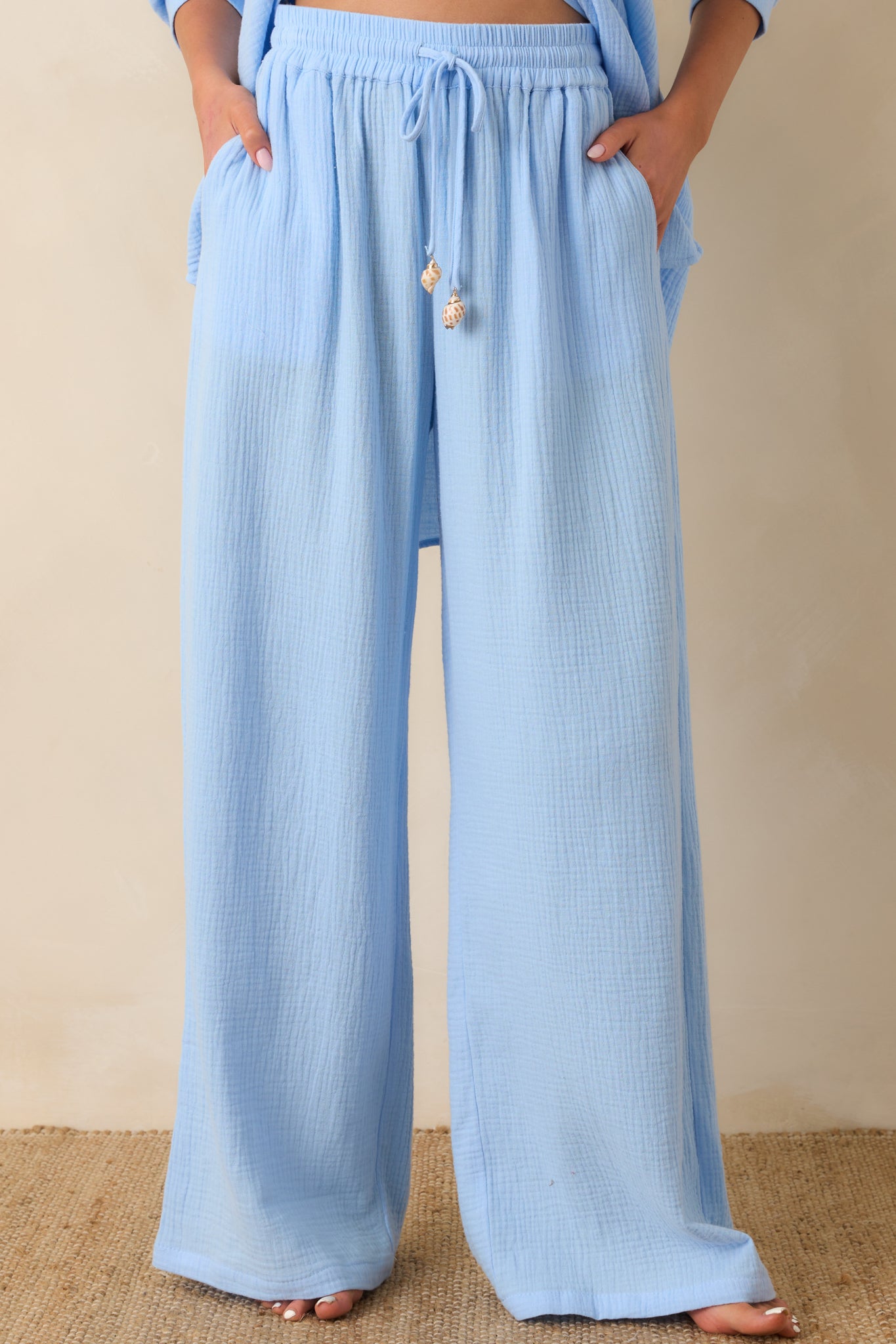 Close front crop of blue pants highlighting elastic waistband, side pockets, and relaxed fit.