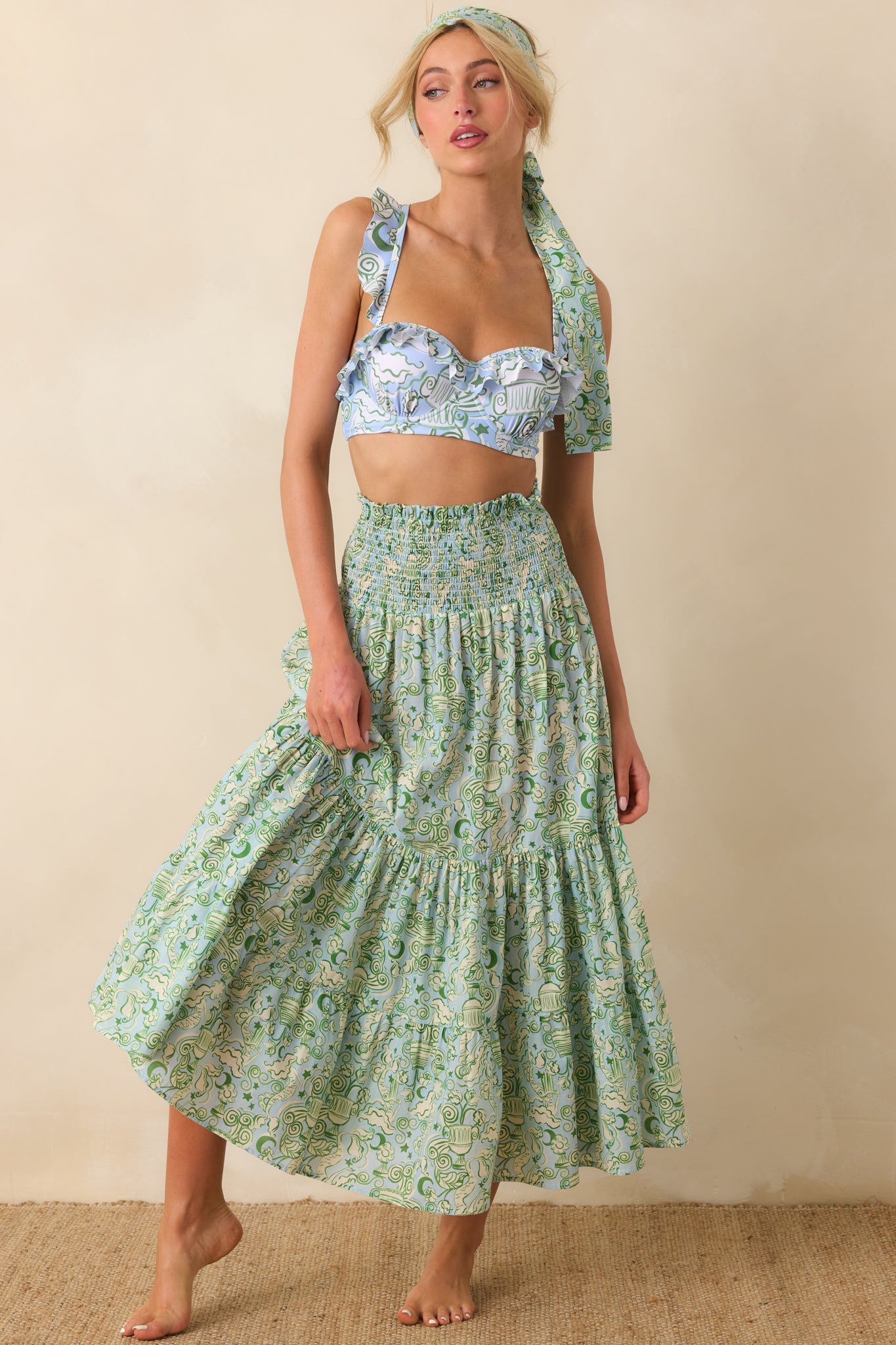 Front view of green strapless dress featuring flexible smocked top and flowing high-rise skirt.