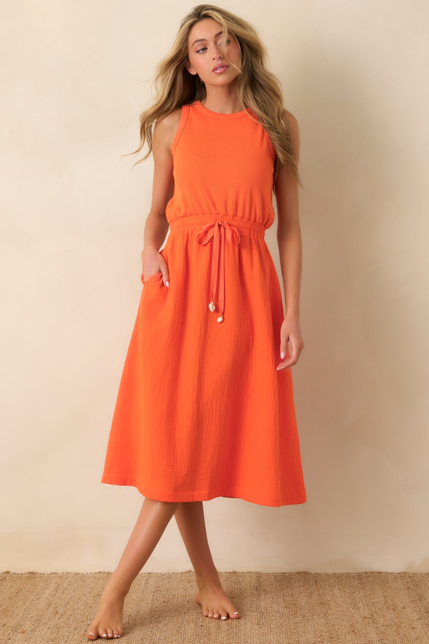 Textured cotton midi dress with round neckline, cinched waist tie, and easy flowing silhouette.