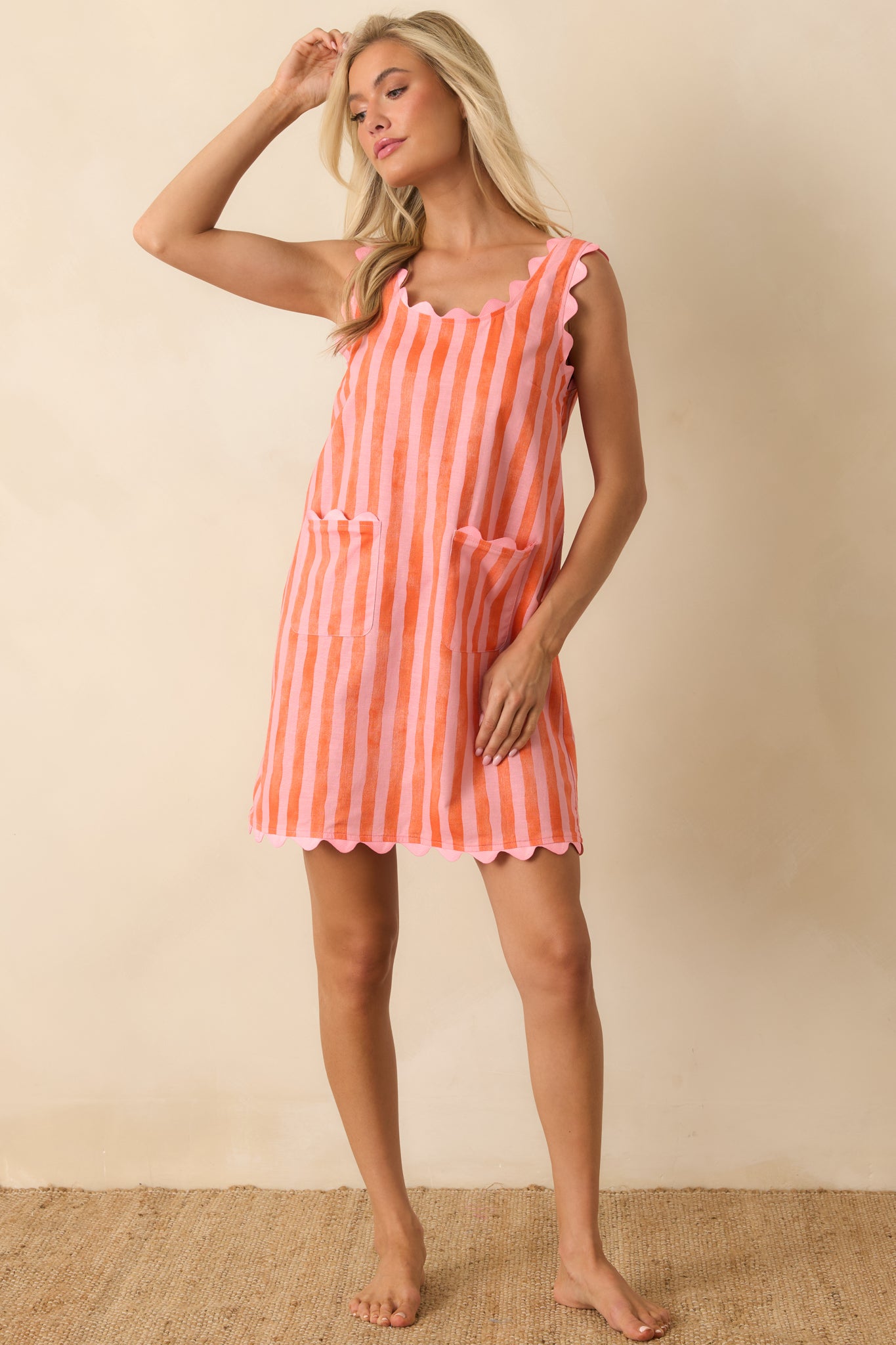 Bright striped shift dress featuring scalloped trim, a comfortable sleeveless design, and a playful mini-length hem.