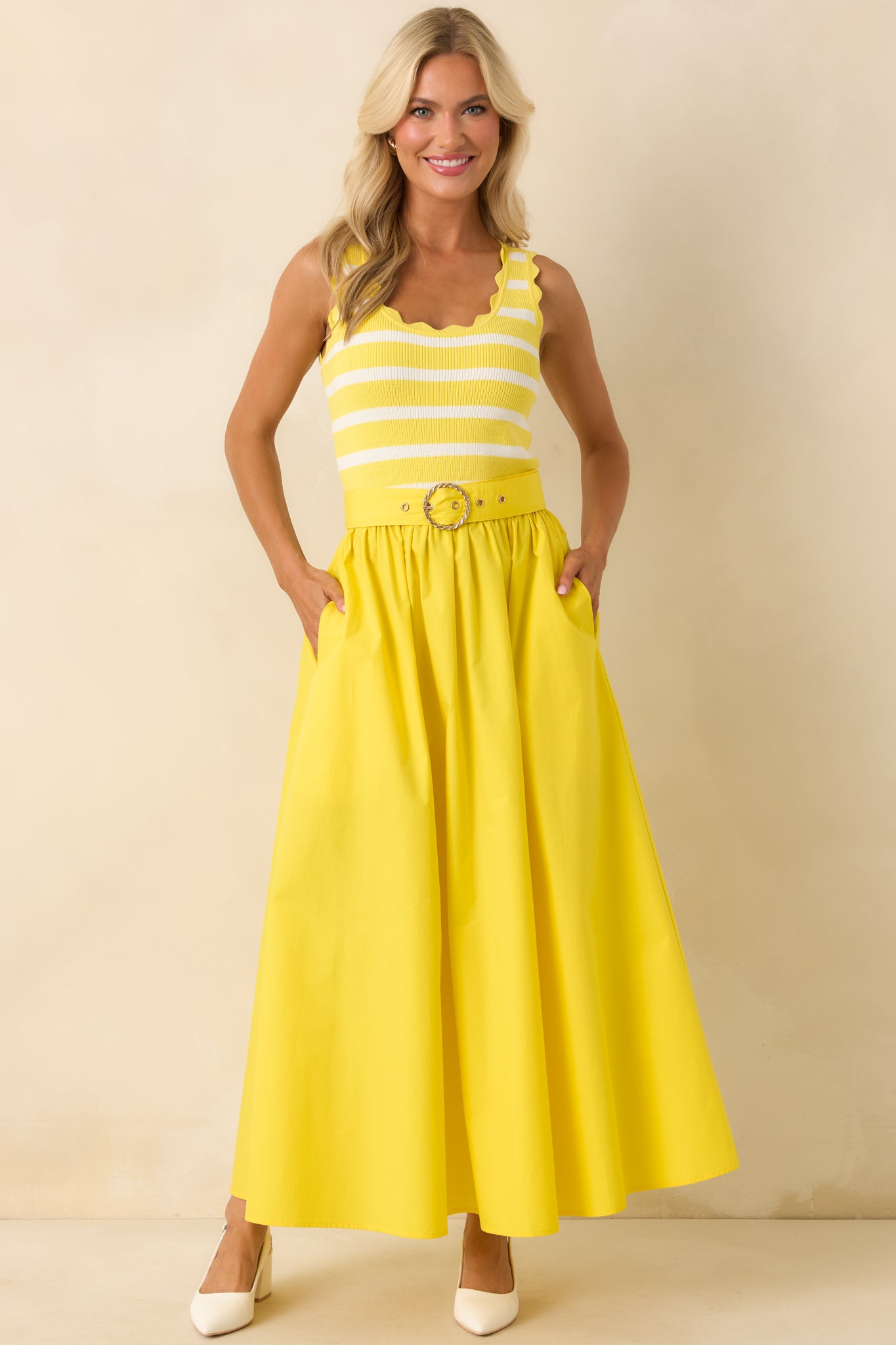 Yellow midi dress with stripe knit bodice, scalloped hem trim, and flowing solid skirt with pockets.