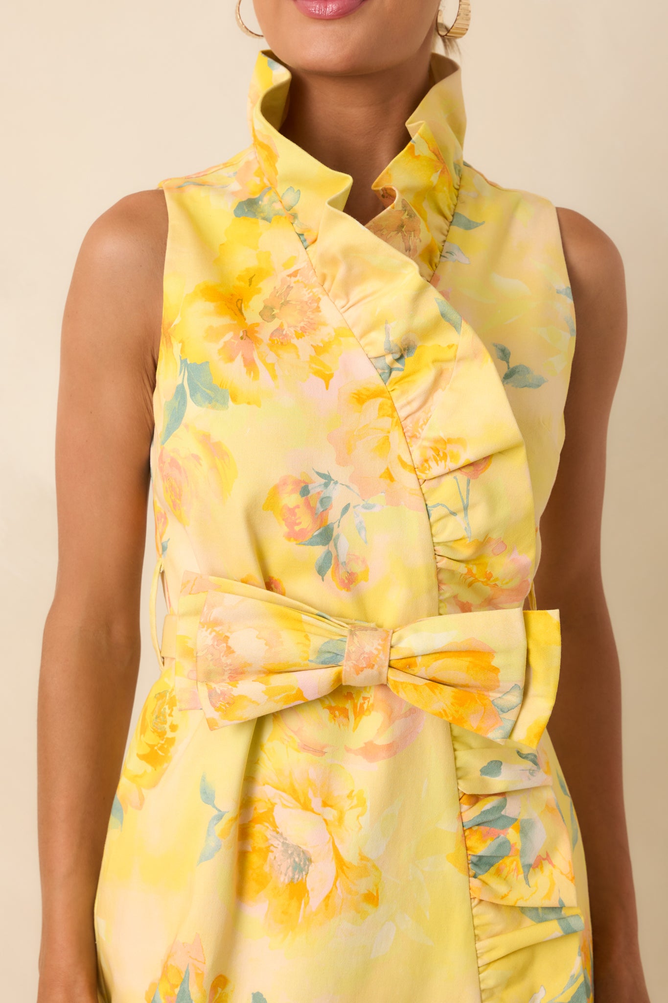 Close-up of silky yellow floral fabric with ruffle trim, concealed side zipper, and soft lining detail.