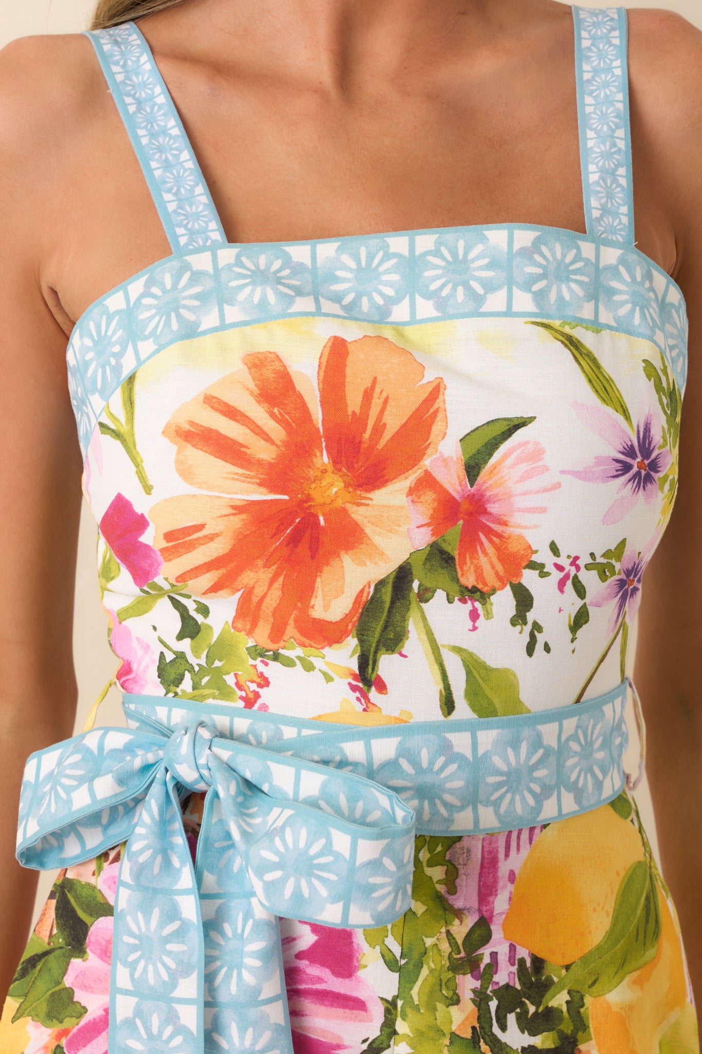 Close-up of scenic coastal print with florals, citrus accents, and contrast border trim.