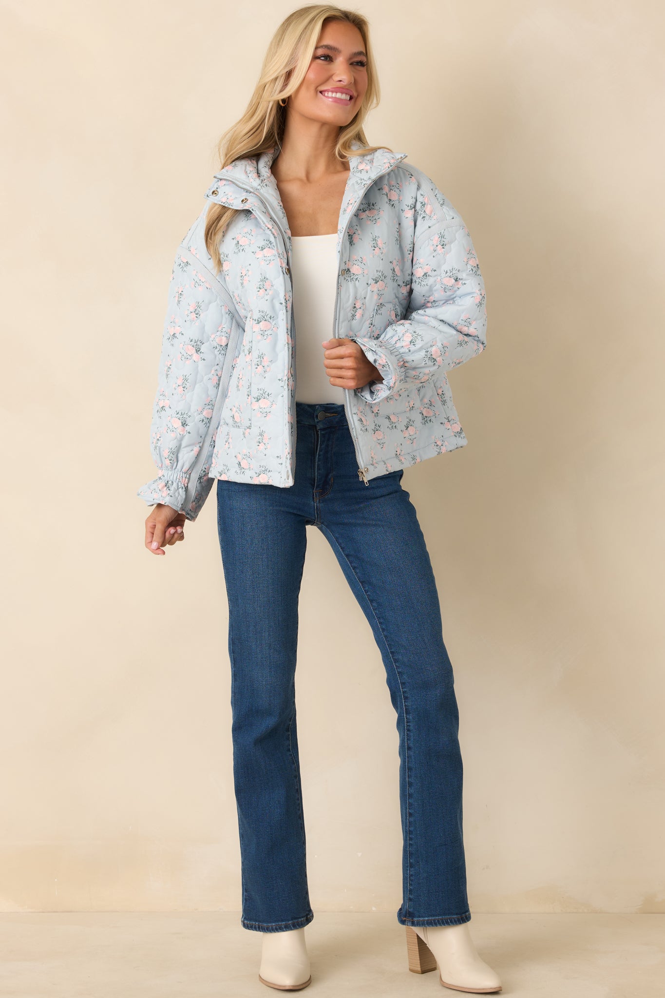 Lightly padded blue quilted jacket with long sleeves, subtle elastic cuffs, and functional front pockets for practical layering.