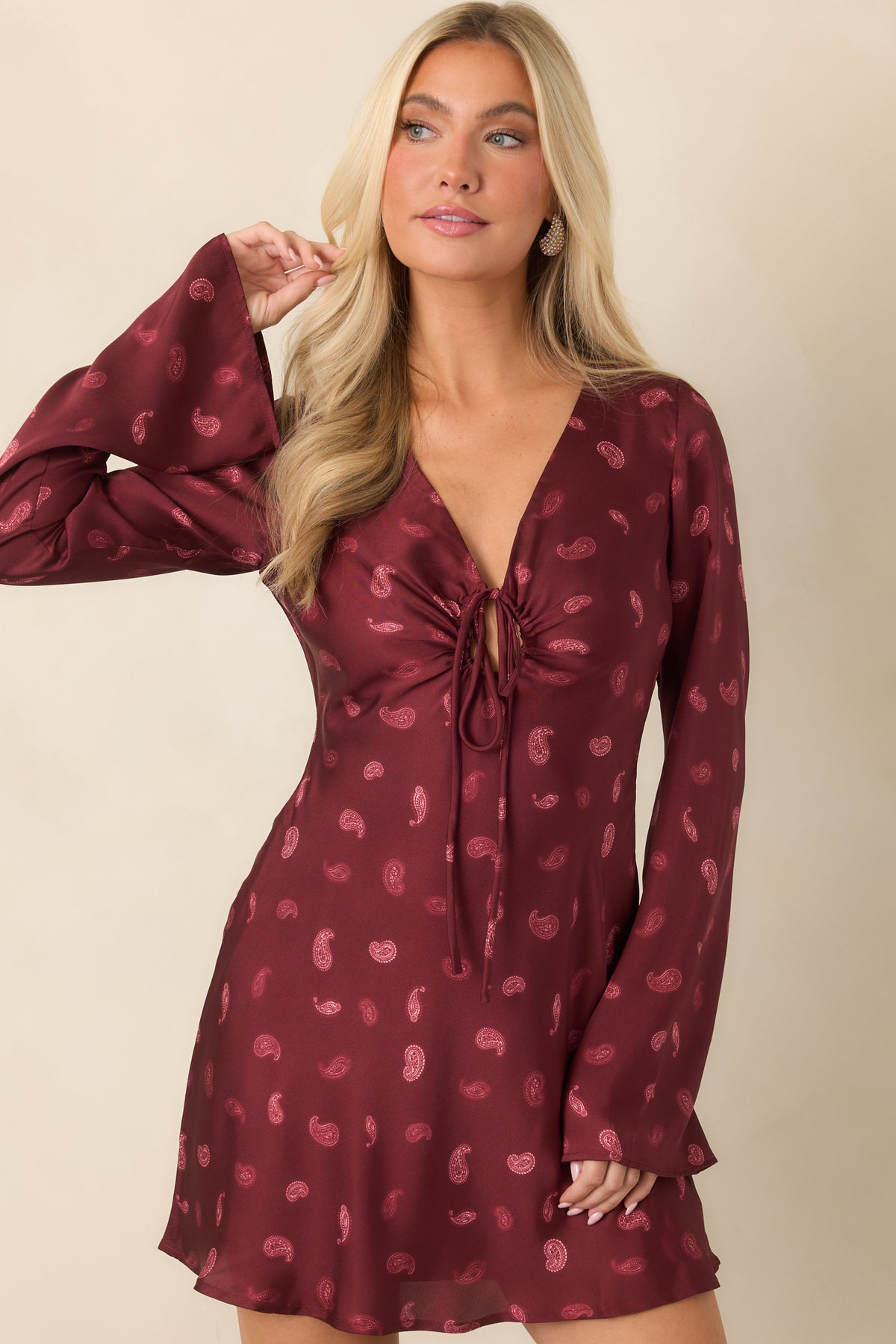 Paisley mini dress featuring long flared sleeves and a fluid satin drape.
