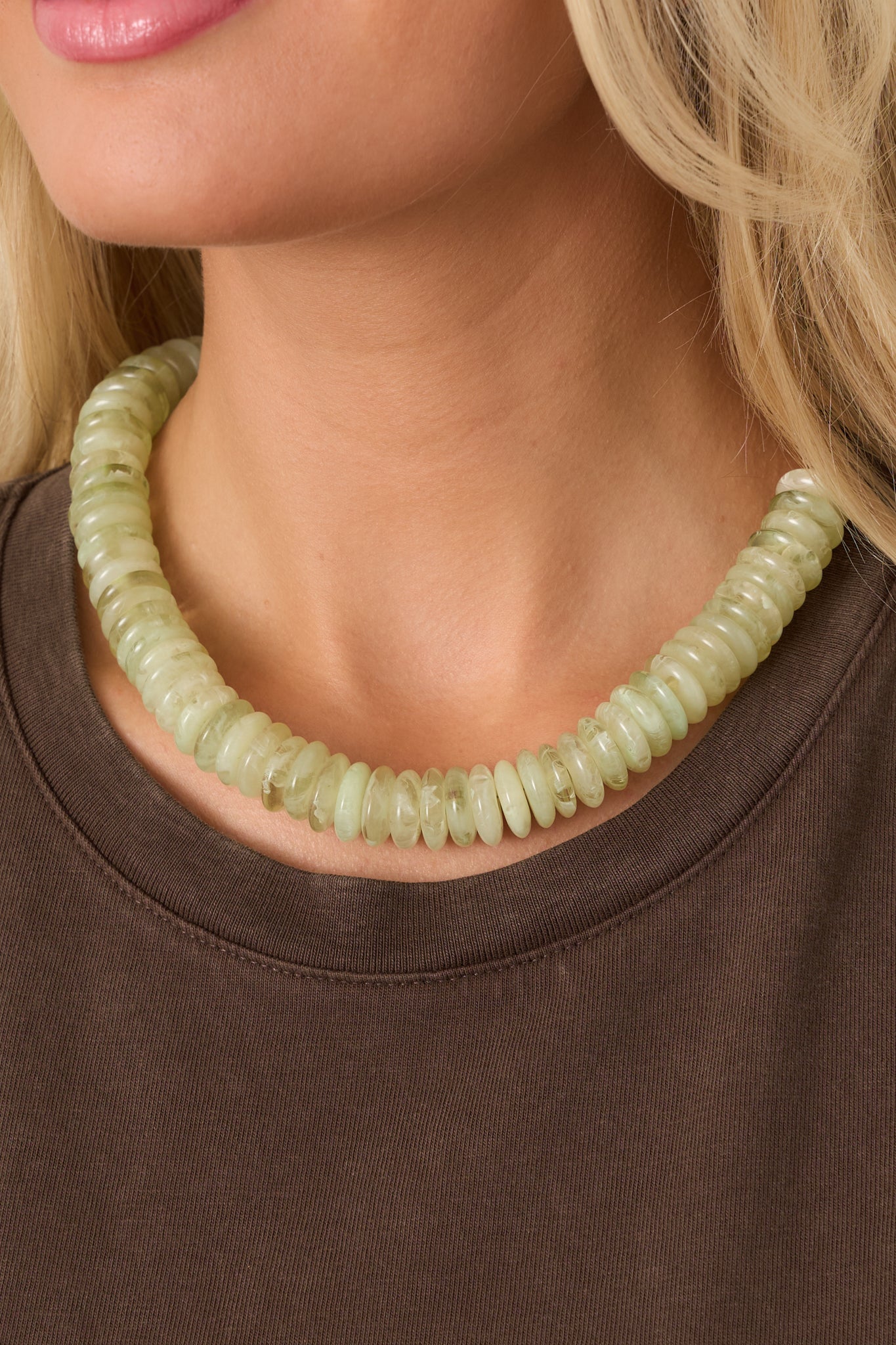 Pale green beaded necklace showcasing chunky, organically shaped discs with subtle variations in texture and transparency.