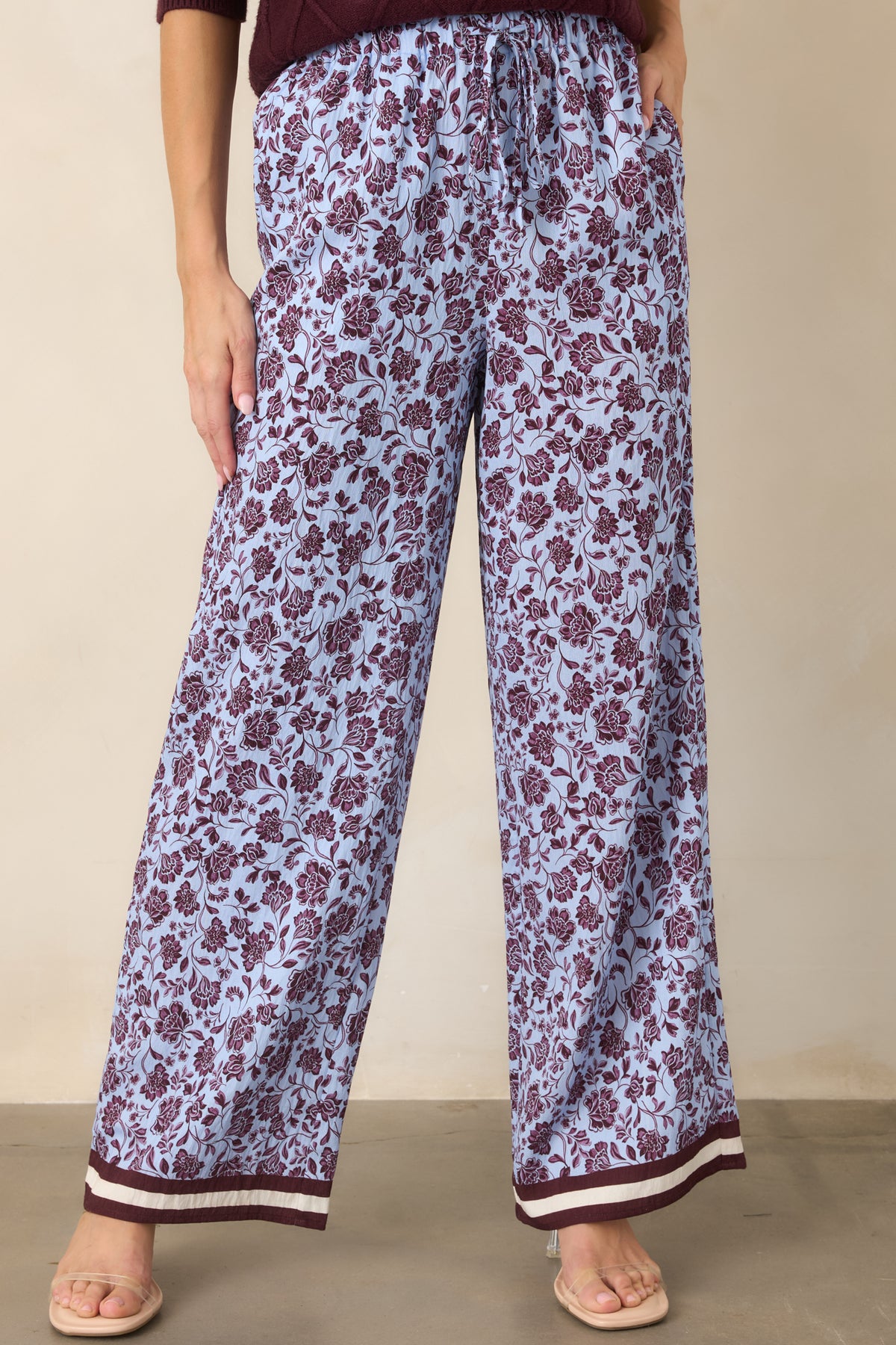Pale lilac pants showcase winding burgundy florals and contrasting striped hem bands in burgundy and ivory.