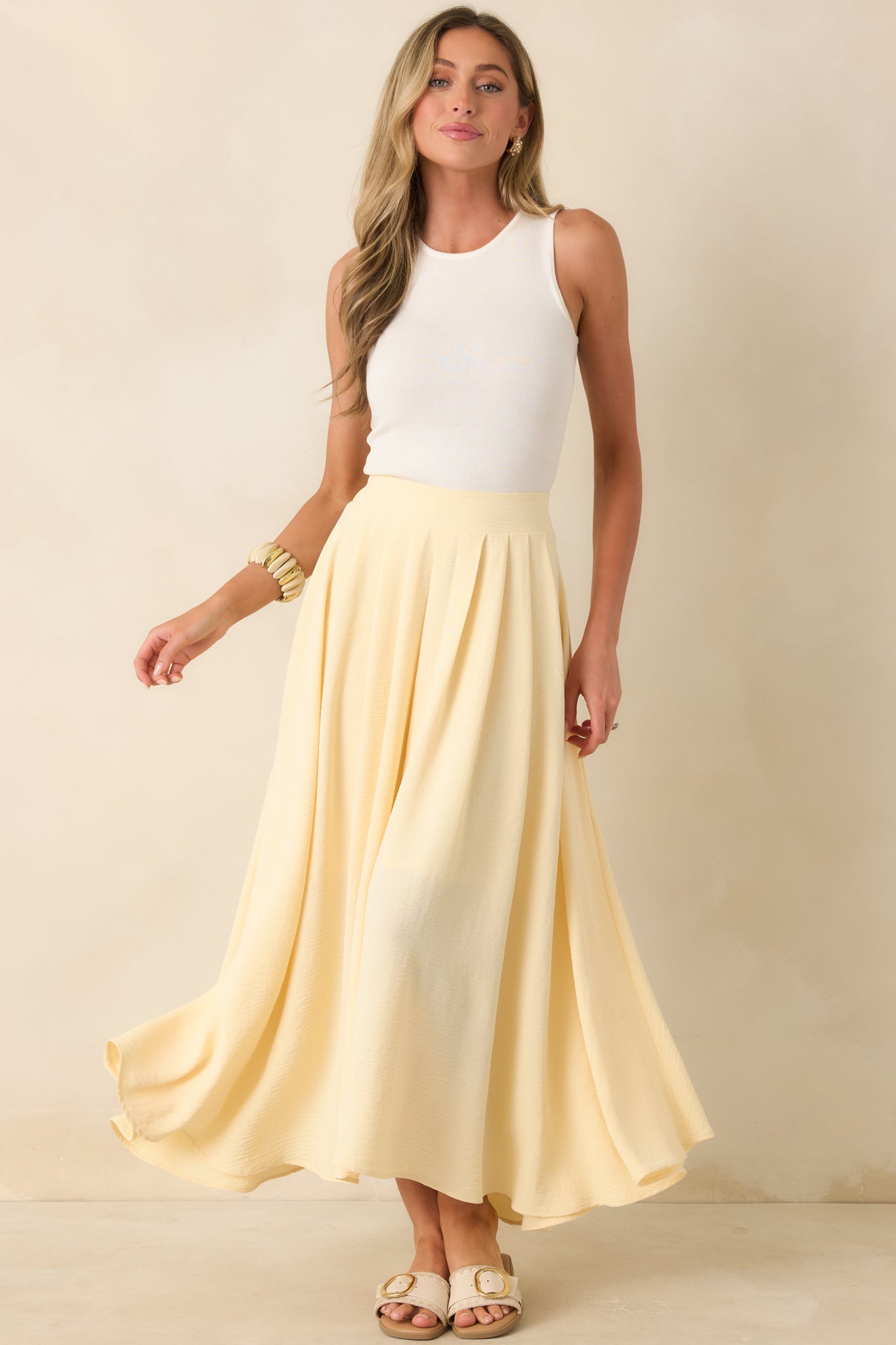 Pale yellow maxi skirt featuring a relaxed draped fit, full lining, and comfortable elastic waist.