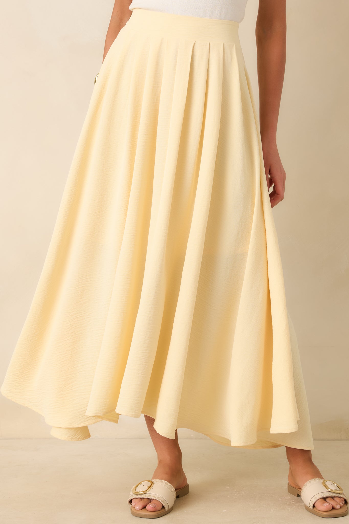 Detailed look at the pale yellow skirt featuring a softly flowing shape and curved hemline.